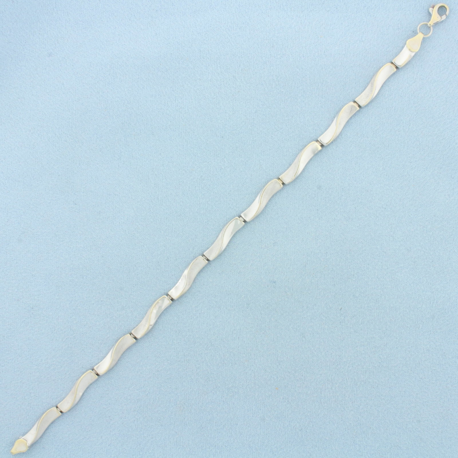 Wave Design Bracelet in 14k White Gold: In 14k White Gold. 7.5 inches long. 4.5mm wide. Lobster clasp. 4.8g.