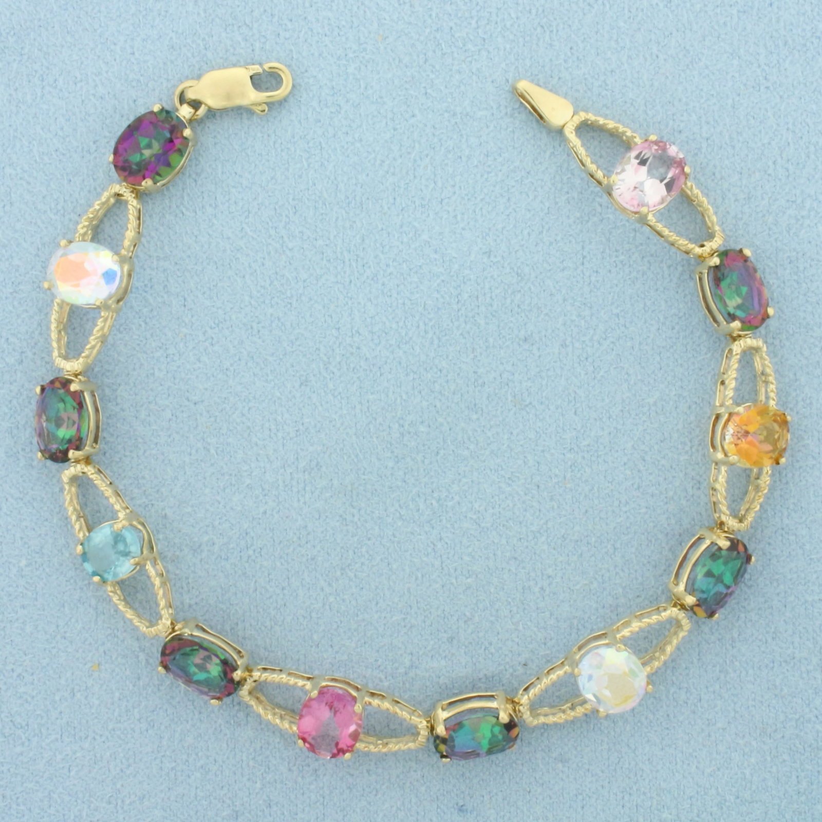 Rainbow Topaz Bracelet in 10k Yellow Gold: In 10k yellow gold. Contains twelve 8x6mm high quality Topaz gemstones with intense color and excellent clarity. 7 inches long. 8mm wide. Lobster clasp. 8.9g.