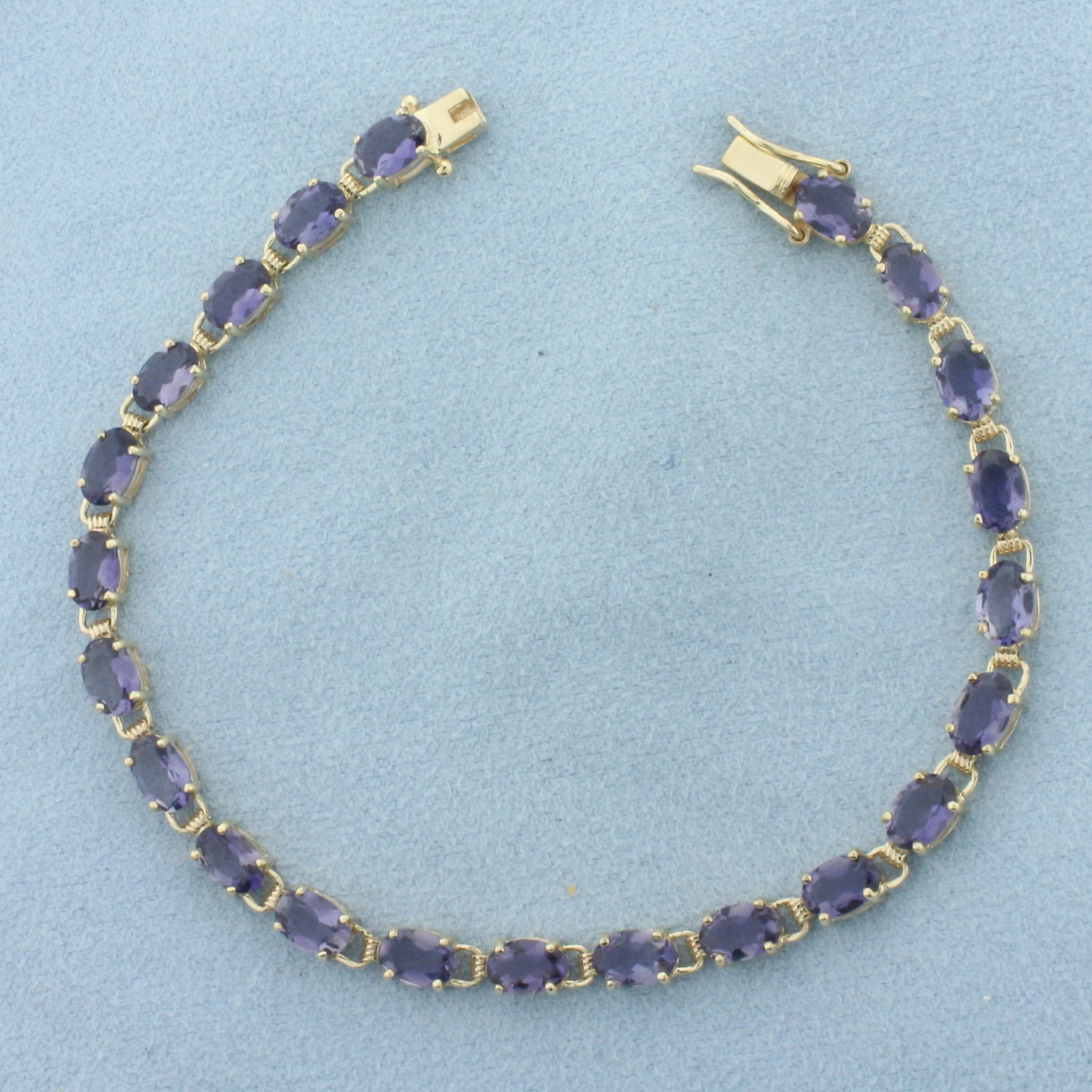 Tanzanite Tennis Bracelet in 10K Yellow Gold: In 10k yellow gold. Measures 7 inches long. Contains 22 high quality natural 6mm Tanzanite gemstones, approximately 11ct TW, with bright color and excellent clarity. Slide clasp with double safety lat