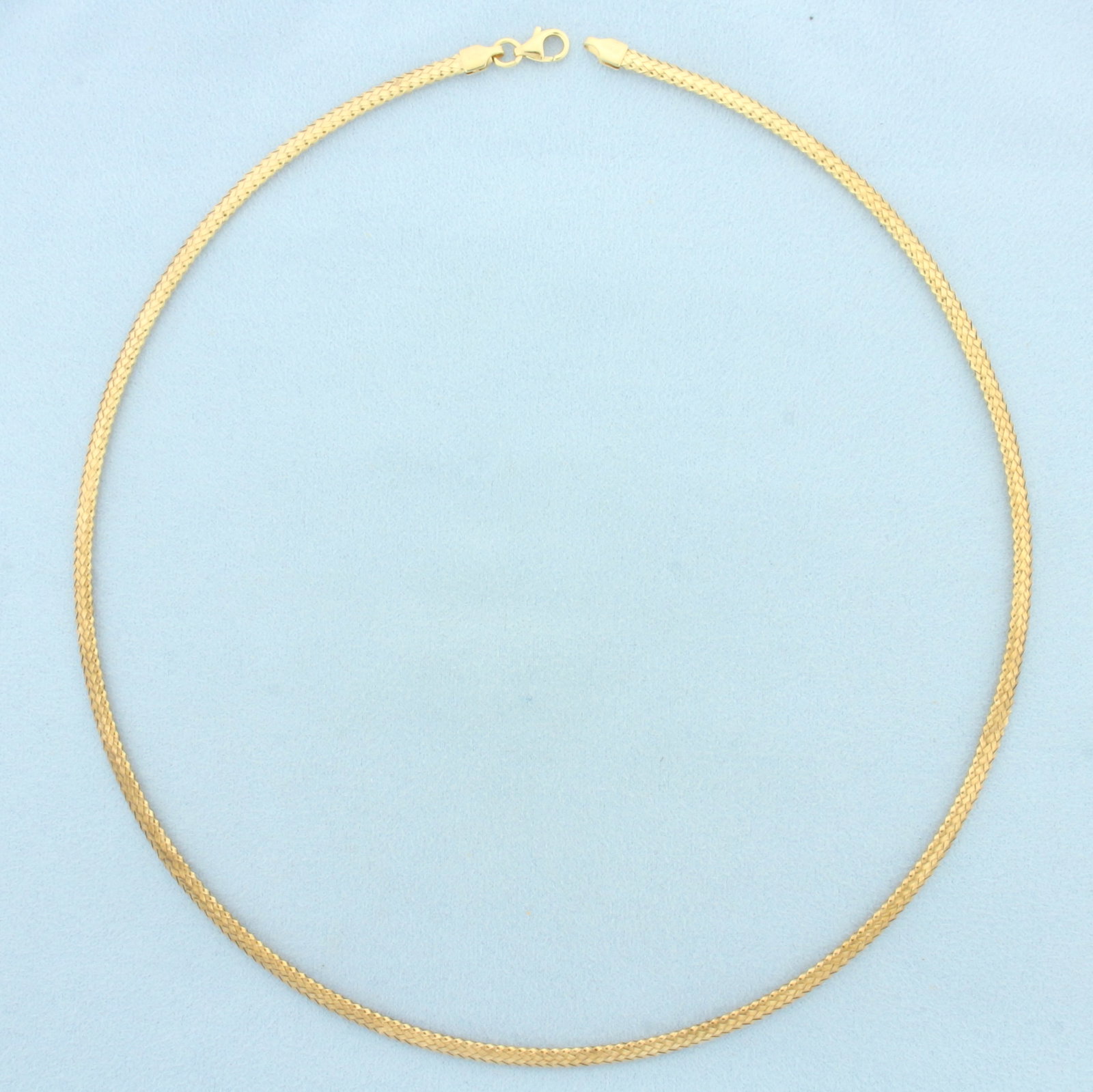 18 Inch Italian Woven Design Omega Necklace in 14k Yellow Gold: In 14k Yellow Gold. 18 inches long. 3.4mm wide. Lobster clasp. 5.9g.