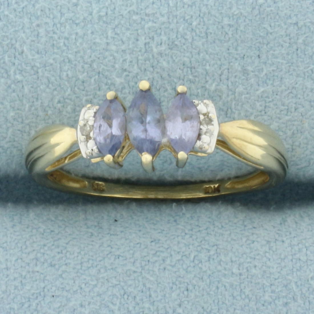 Tanzanite and Diamond Ring in 10k Yellow Gold: In 10k Yellow Gold. Contains one 6x3mm and two 5x2.5mm high quality natural Tanzanite gemstones with bright color and excellent clarity. Also contains two high quality 1/2pt diamonds. Size 8. 2.0g.