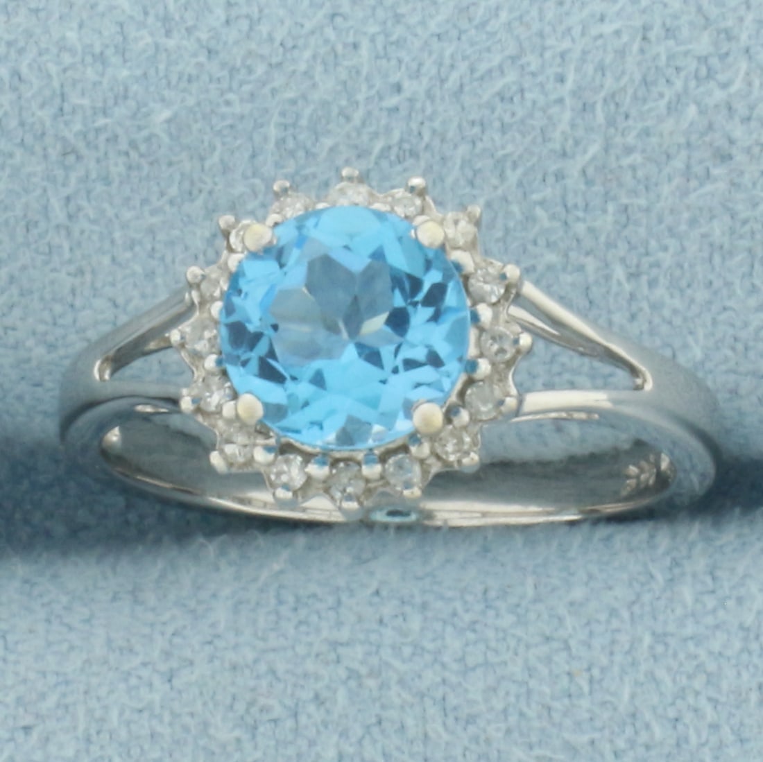 Swiss Blue Topaz and Diamond Halo Ring in 14k White Gold: In 14k White Gold. Contains one 7mm high quality natural Swiss Blue Topaz gemstone, approximately 1.25ct, with electric blue color and excellent clarity. Also contains sixteen high quality 1/2pt diamo