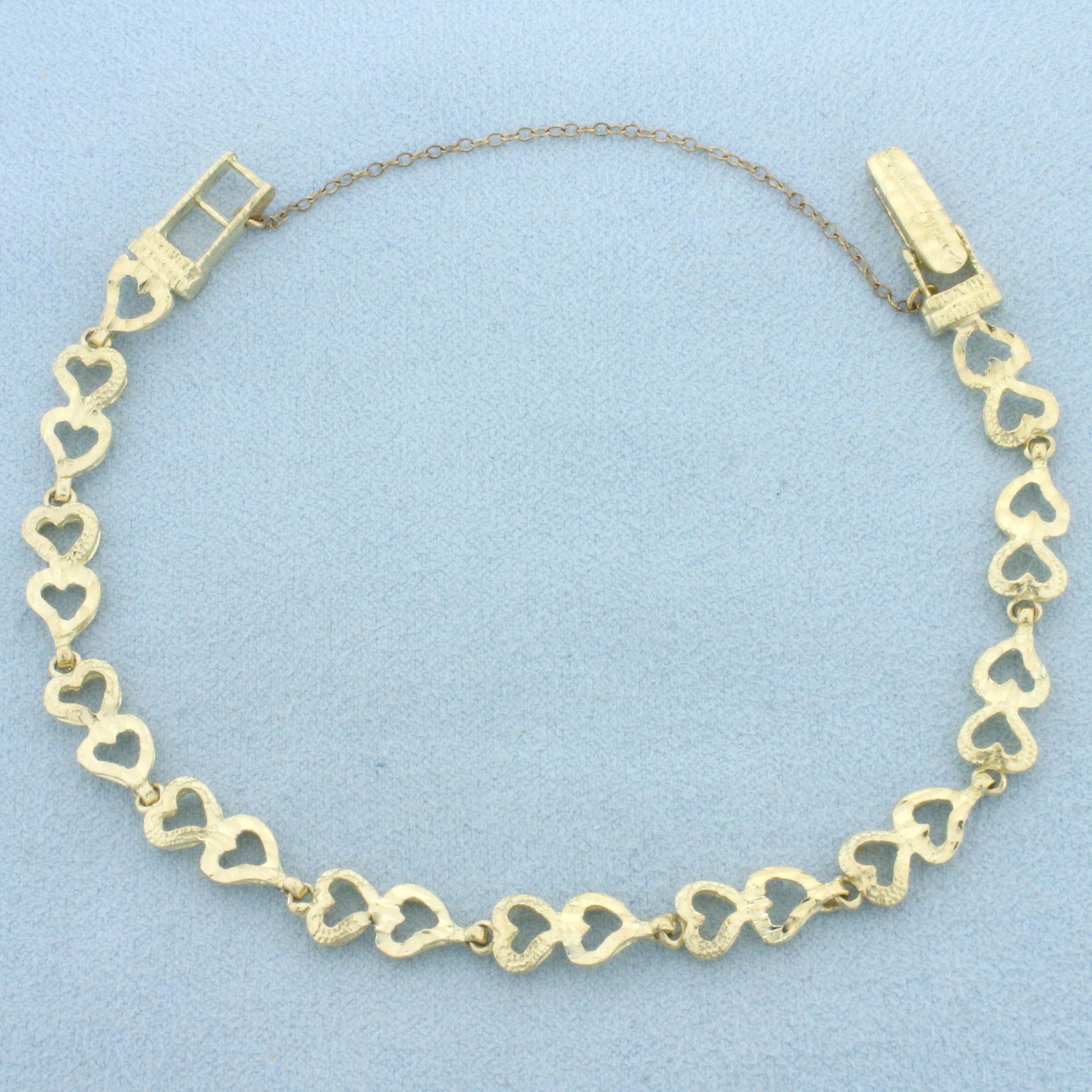 Diamond Cut Heart Link Bracelet in 10k Yellow Gold: In 10k Yellow Gold. 7 1/4 to 7 1/2 inches long (adjustable). 6.6mm wide. Locking clasp with safety chain. 7.6g.