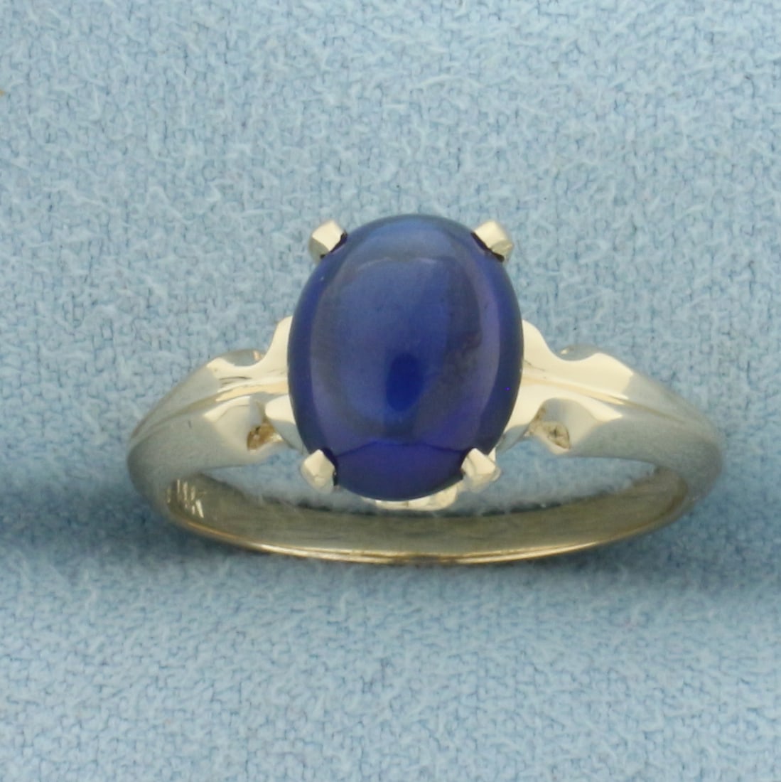 Sapphire Cabochon Solitaire Ring in 14k Yellow Gold: In 14k Yellow Gold. Contains one 9x7mm high quality oval cabochon Sapphire gemstone with intense color and excellent clarity. Size 6. 2.7g.