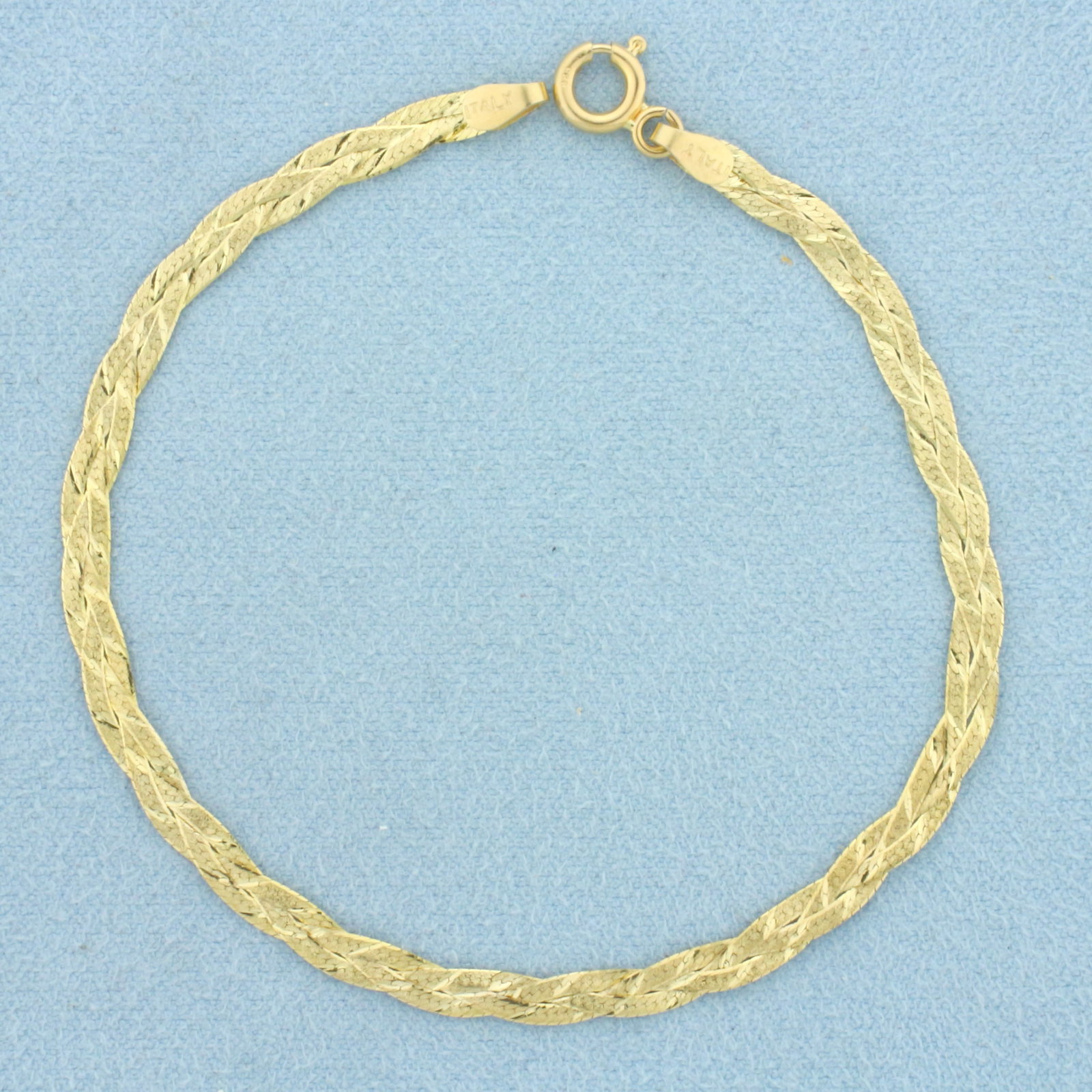 Braided Herringbone Link Bracelet in 14k Yellow Gold: In 14k Yellow Gold. 7 1/8 inches long. 3.2mm wide. Spring clasp. 2.0g.