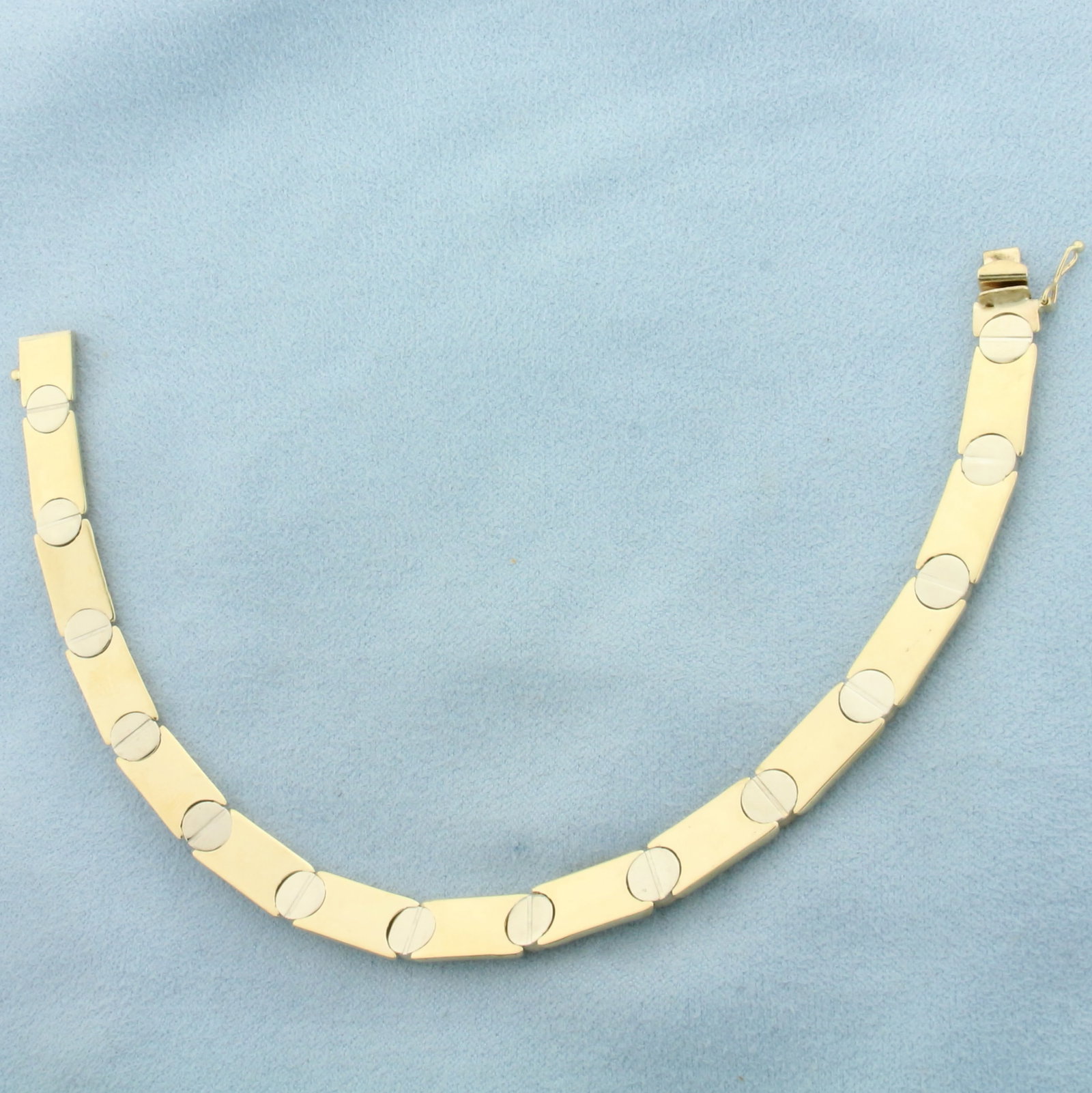 Italian Two Tone Screw Head Bracelet in 14k Yellow and White Gold: In 14k Yellow and White Gold. 8 inches long. 1/4 inch wide. Italian made. Slide clasp with safety latch. 12.7g.