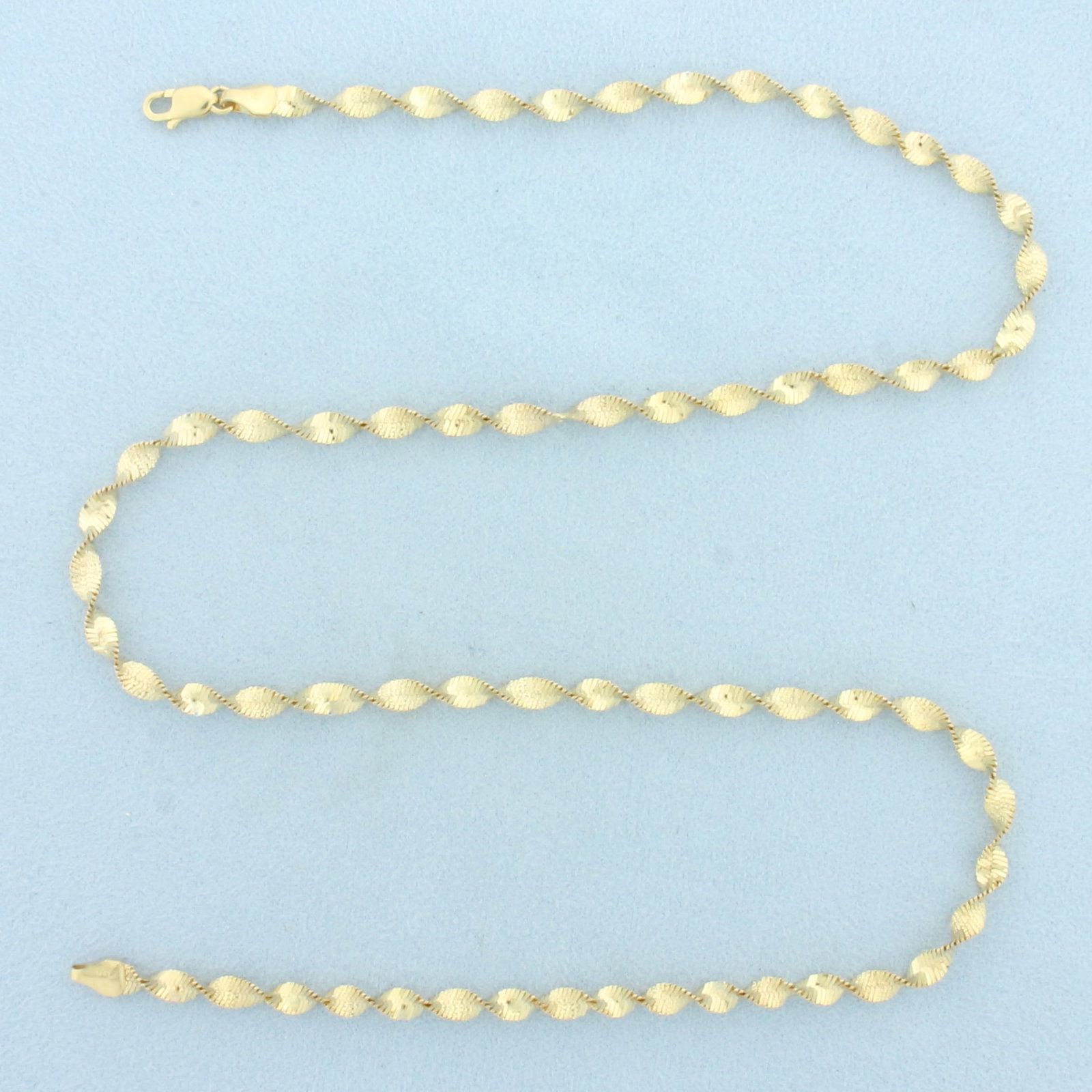 Italian 20 Inch Twisting Herringbone Link Chain Necklace in 14k Yellow Gold: In 14k Yellow Gold. 20 inches long. 4mm wide. Italian made. Lobster clasp. 8.5g.