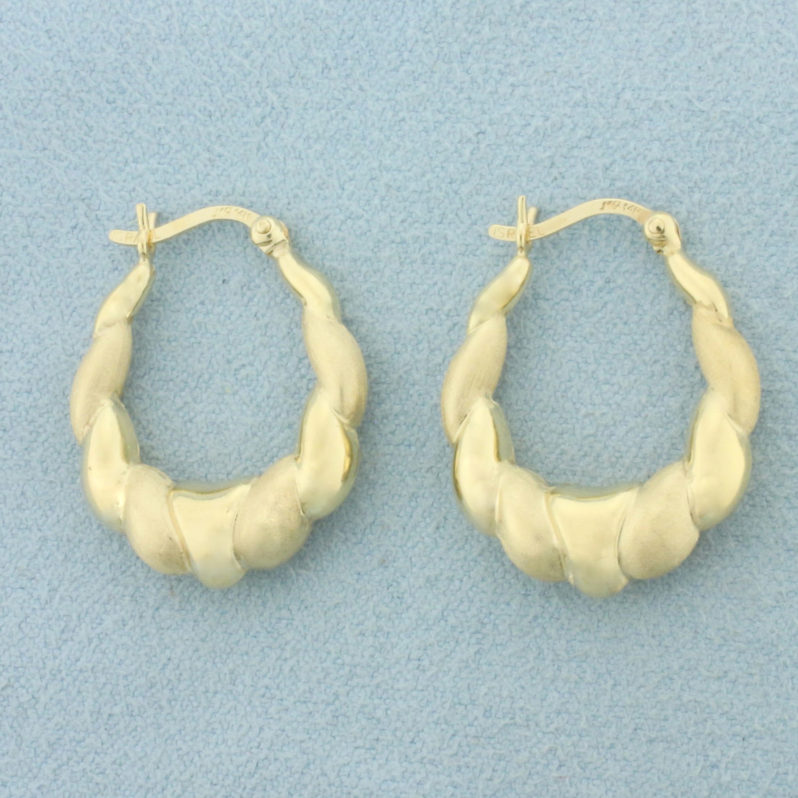 Satin and High Polish Finish Puffy Hoop Earrings in 14k Yellow Gold: In 14k Yellow Gold. 7/8 inch long. 3/4 inch wide. Leverbacks. 2.5g.