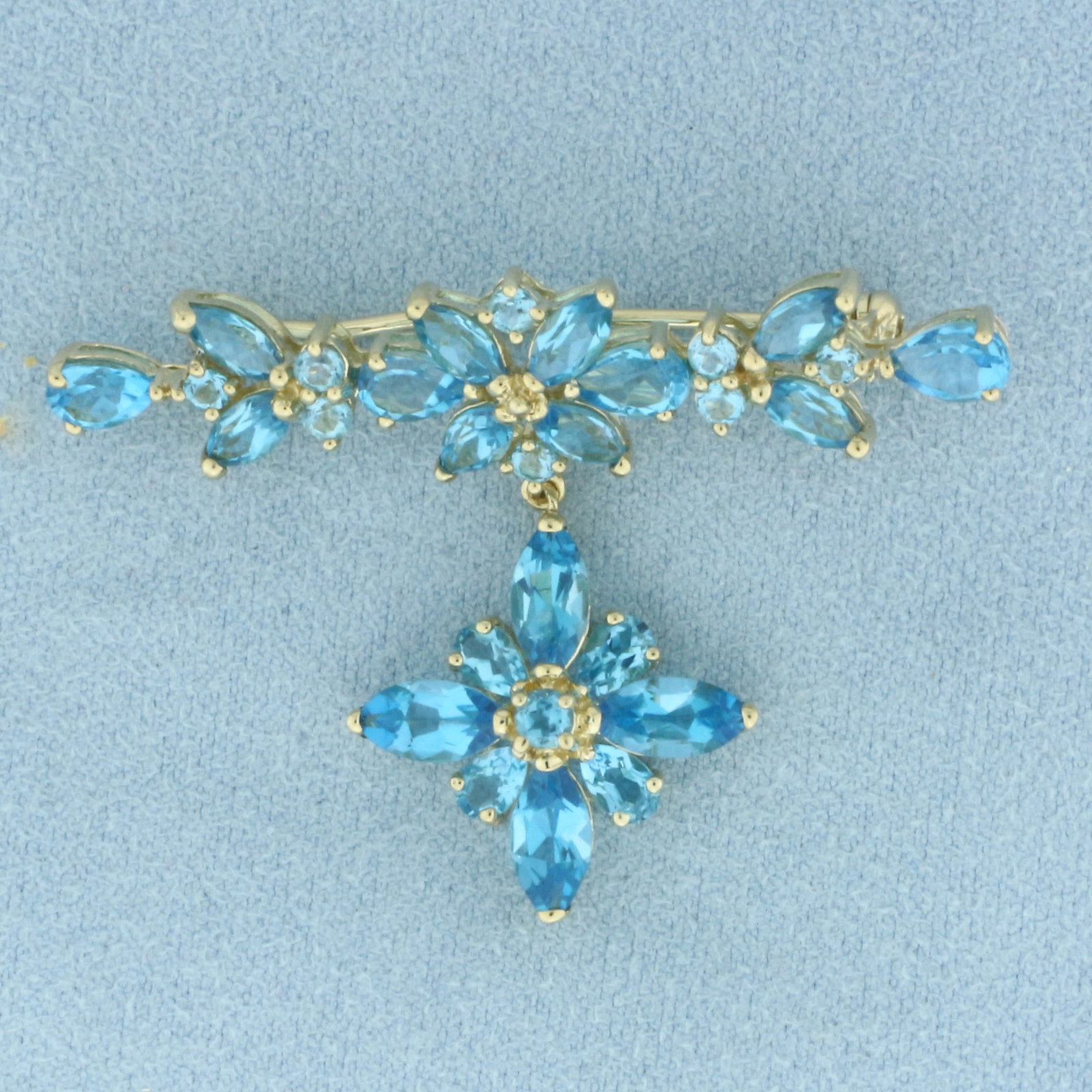Blue Topaz Flower Dangle Brooch Pin in 10k Yellow Gold: In 10k Yellow Gold. Contains four 4x8mm and eight 3x6mm marquise, four 4x6mm and four 3x6mm pear cut, and eight 2mm and one 3mm round high quality natural Swiss Blue Topaz gemstones, approximately