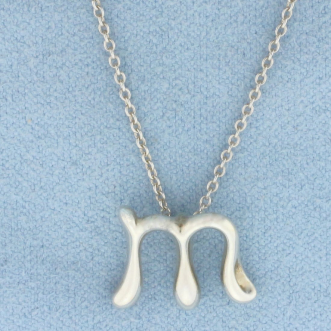 Tiffany and Co. Elsa Peretti "M" Initial Necklace in Sterling Silver: In .925 Sterling Silver. Guaranteed Authentic. "M" pendant is 14x12mm. 16 inches long chain. 0.8mm wide. Spring clasp. 2.8g.