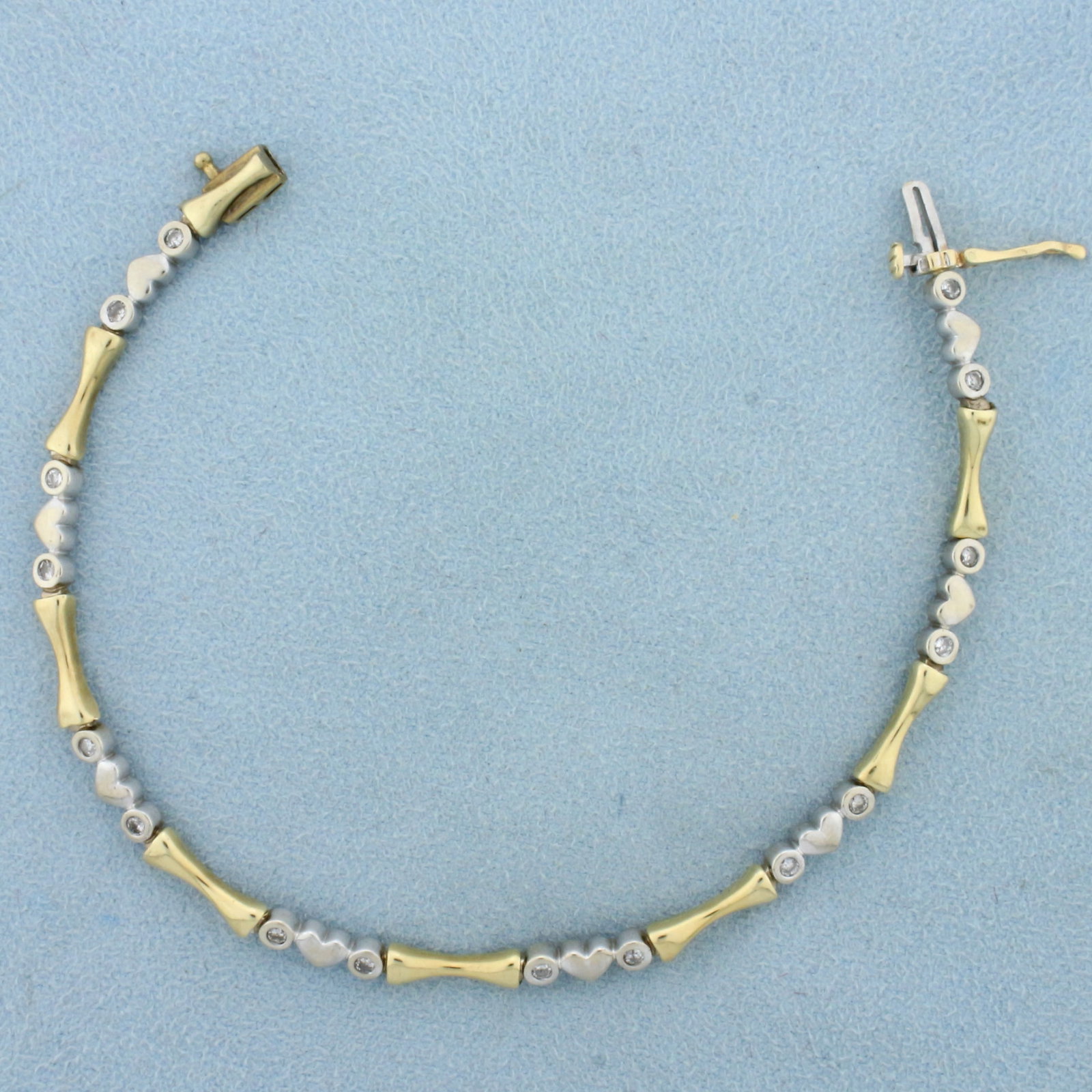 Diamond Heart Link Two Tone Bracelet in 14K Yellow and White Gold: In 14K Yellow and White Gold. Contains sixteen high quality diamonds, 1/3ct TW, H color/I clarity. 7 inches long, 3.7mm wide, with a safety clasp. 7.6g.