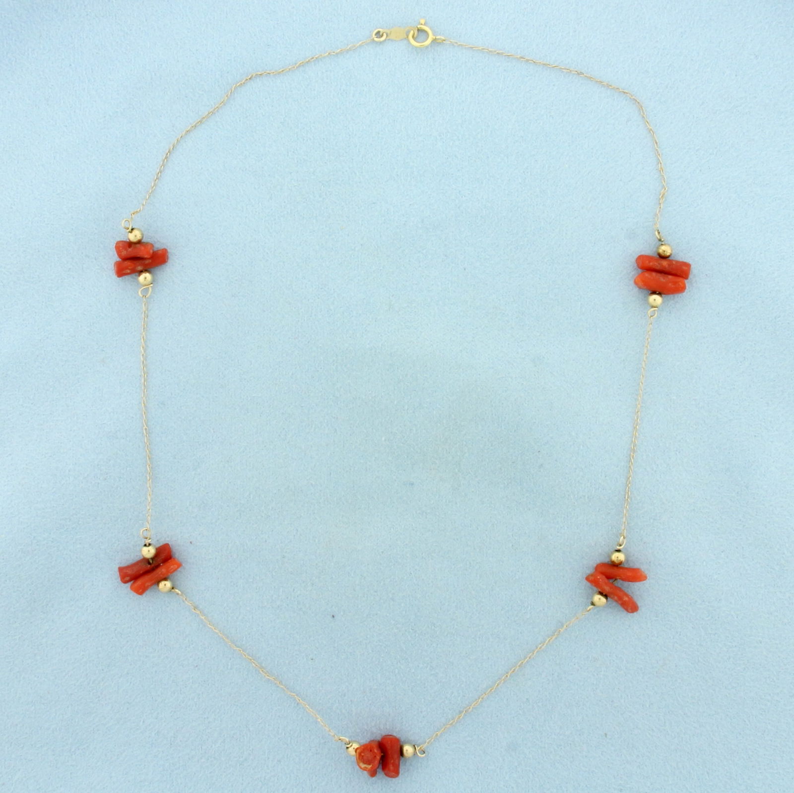 Red Coral Station Necklace in 14k Yellow Gold: In 14k Yellow Gold. Contains ten 8 to 11mm high quality red coral gemstones with intense color. 17 inches long. 0.7mm wide chain. Spring clasp. 3.2g.