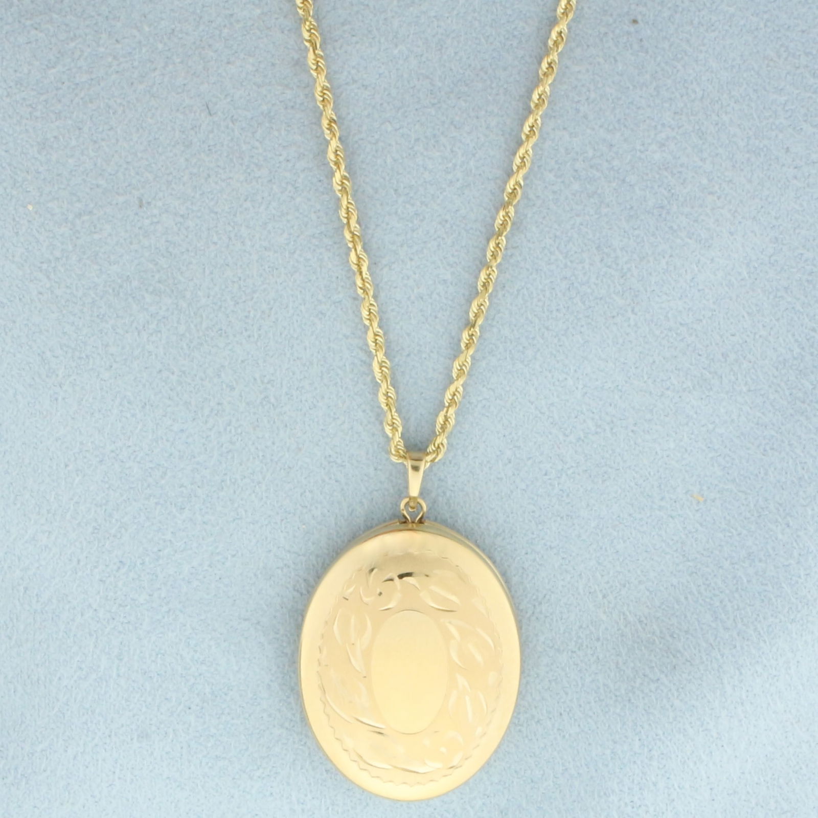Oval Locket on Rope Chain Necklace in 14k Yellow Gold: In 14k Yellow Gold. Oval locket is 1 inch by 3/4 inch. Chain is 24 inch long rope link, 2mm wide. Lobster clasp. 10.0g