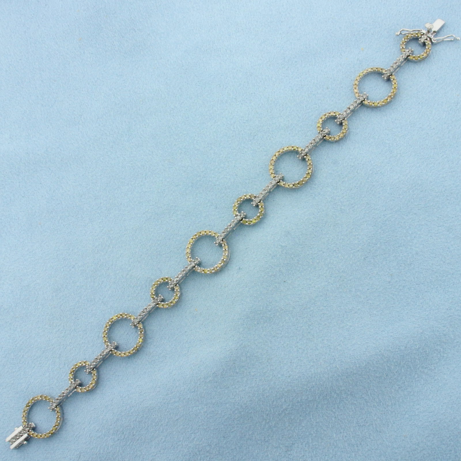 Yellow and White Diamond Circle Link Bracelet in 10k White Gold: In 10k White Gold. Contains eighty-nine high white and one hundred and forty-five high yellow high quality diamonds, 2ct TW. 7 1/4 inches long. 1/2 inch wide. Slide clasp with double safety latch. 9.5