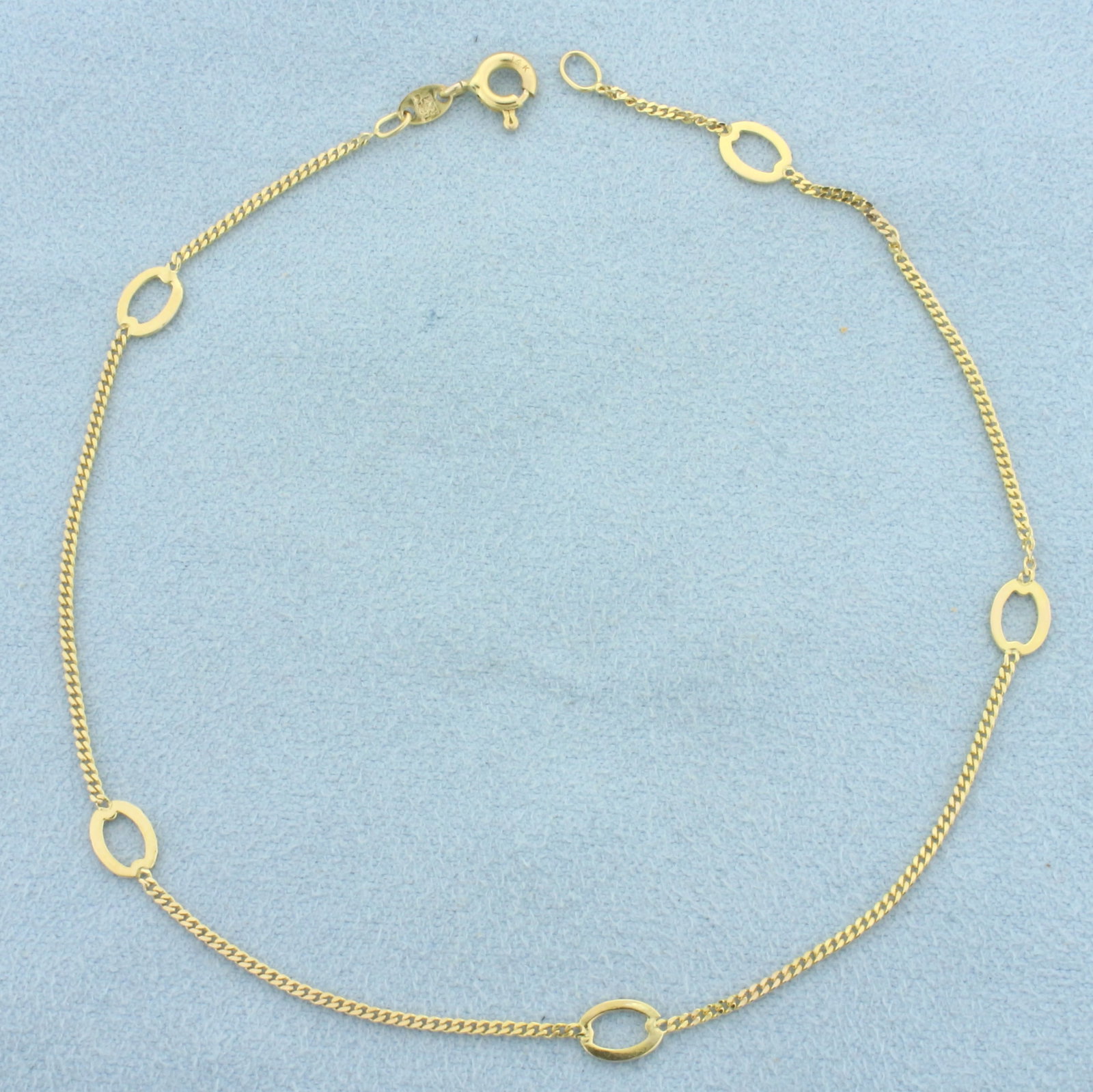 Italian Oval Station Anklet in 14k Yellow Gold: In 14k Yellow Gold. 9 1/2 inches long. 4.6mm wide at widest point. Italian made. Spring clasp. 1.5g.