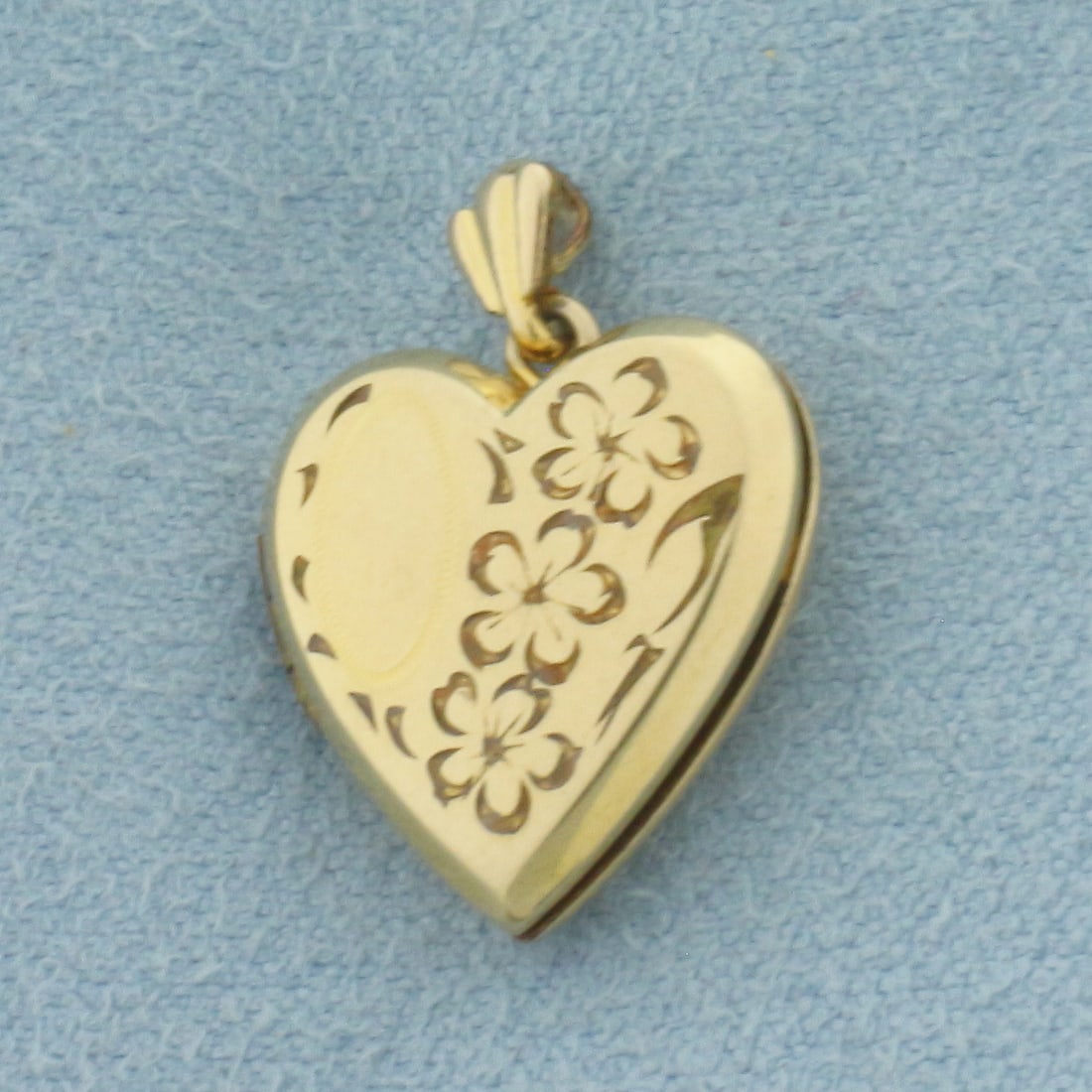 Vintage Heart Locket Pendant: Gold filled. 3/4 inch long (including jump ring). 5/8 inch wide. Opens to 1 1/8 inch wide. Engraved flower design. 1.5g.