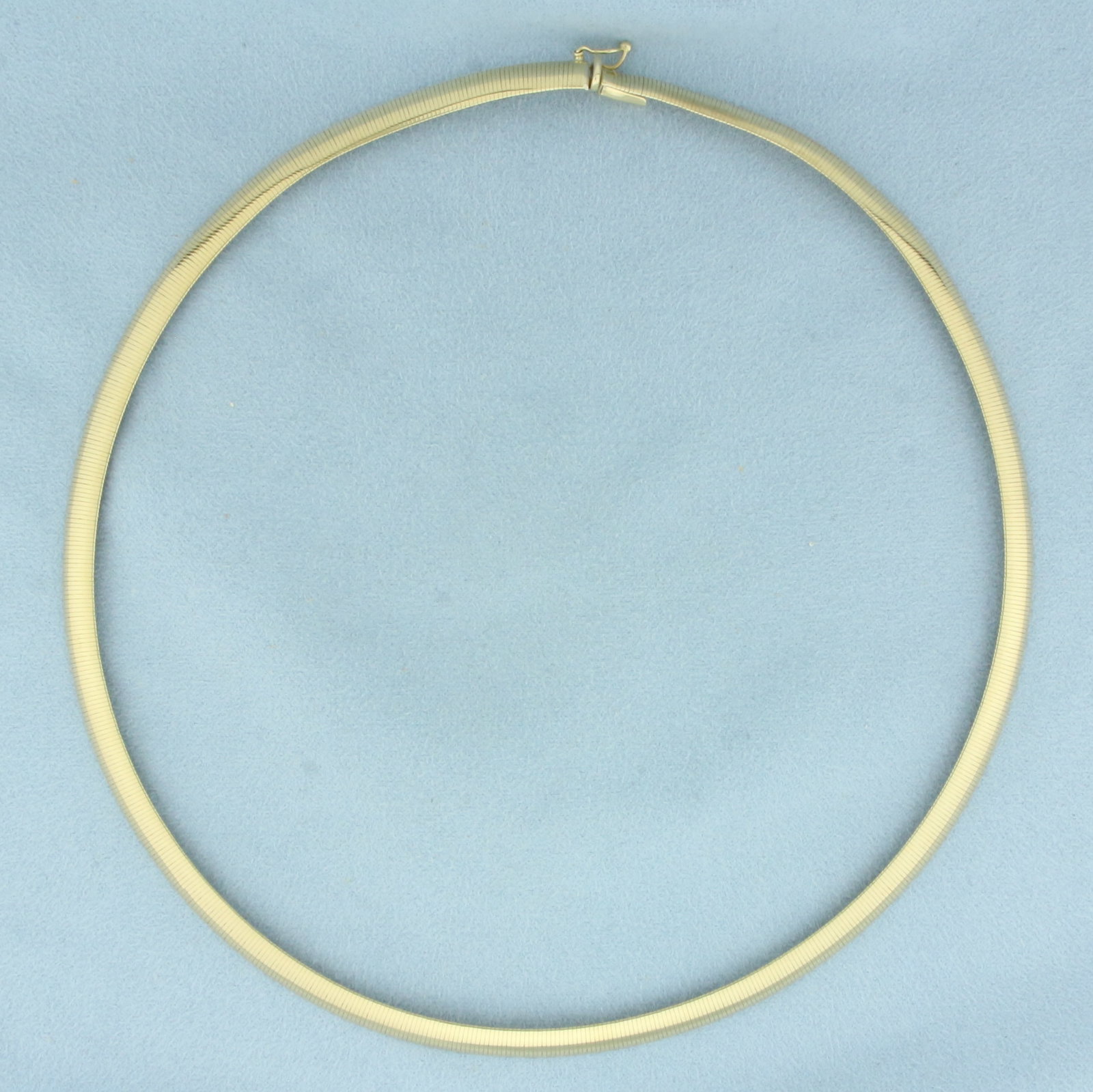 17 Inch Italian Omega Necklace in 10K Yellow Gold: In 10k yellow gold. Italian made. Measures 5.8mm wide and 17 inches long. Concealed slide claps with safety latch. 14.7g