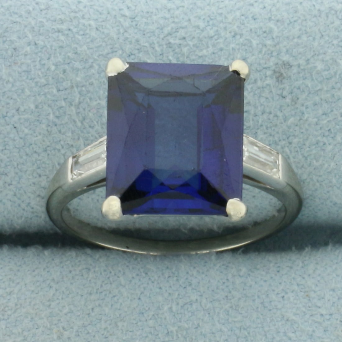 Lab Sapphire and Diamond Ring in 18k White Gold: In 18k White Gold. Contains one 12x10mm high quality Lab created Sapphire gemstone, approximately 6cts, with intense color and excellent clarity. Also contains two 4mm high quality baguette diamonds, 