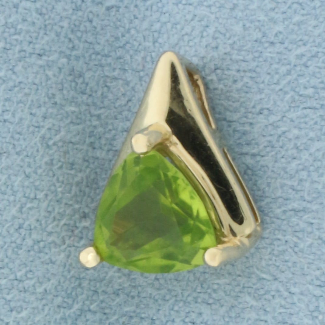Peridot Pendant in 14k Yellow Gold: In 14k Yellow Gold. Contains one 8mm high quality trillion cut natural Peridot gemstone, approximately 1.25ct, with vibrant color and excellent clarity. 1/2 inch long. 3/8 inch wide. 1.9g.