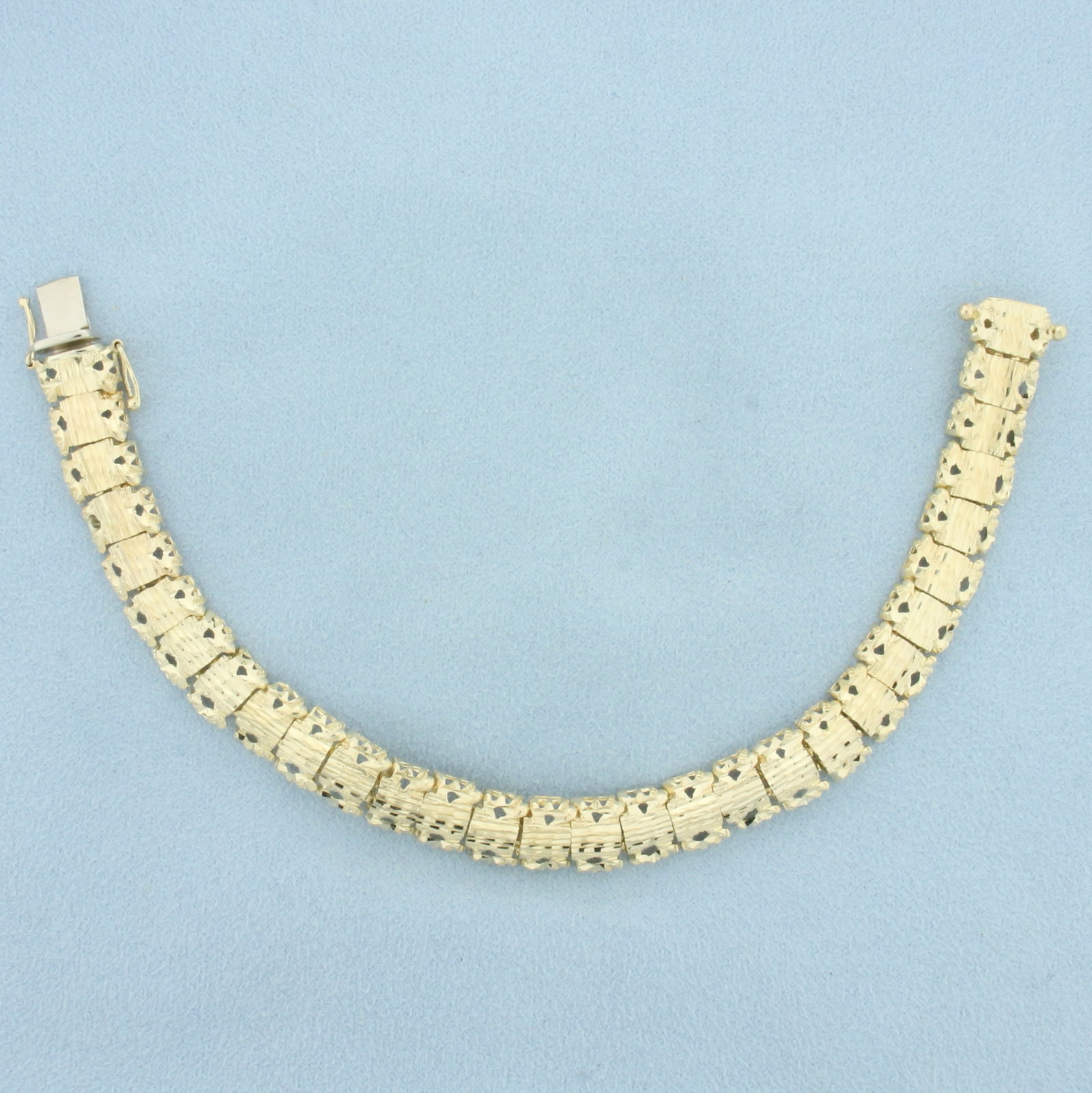 Designer Cutout Nugget Link Bracelet in 14k Yellow Gold: In 14k yellow gold. 7.25 inches long, 3/8inch wide. Concealed slide clasp with 2 safety latches. 17.7g.