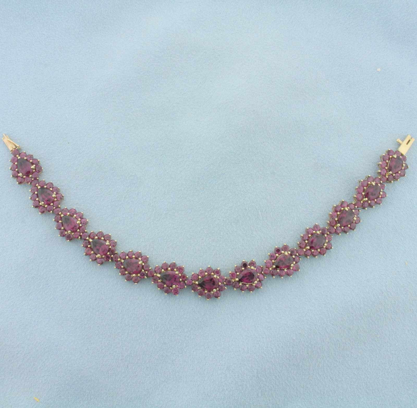 18ct Purple Tourmaline Bracelet in 10k Yellow Gold: In 10k yellow gold. Contains thirteen 7x5mm pear cut and 143 2.5mm round high quality natural Tourmaline gemstones with intense purple color and excellent clarity. Approximately 18ct TW. 6 1/2 inches 