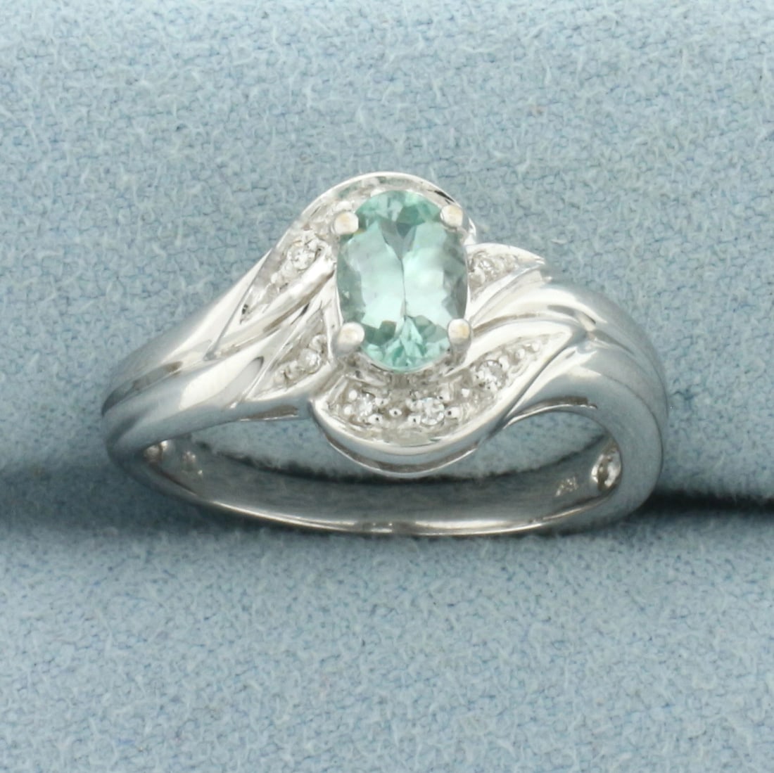 Paraiba Tourmaline and Diamond Ring in 18k White Gold: In 18k White Gold. Contains one 6.3x4.4mm high quality oval cut natural Paraiba Tourmaline gemstone, approximately 1/2ct, with intense color and excellent clarity. Also contains eight high quality