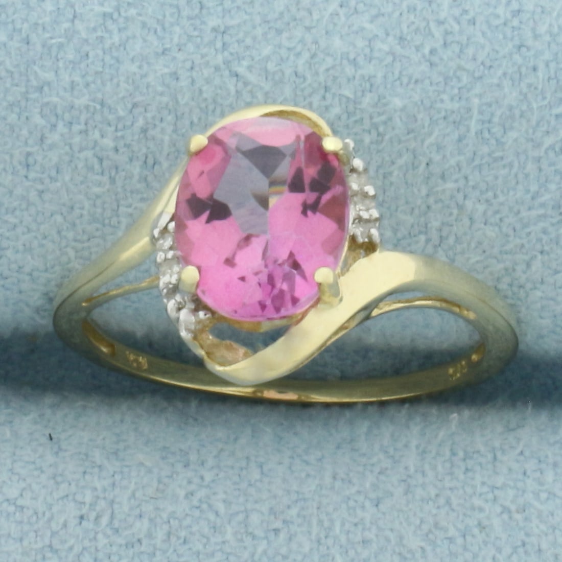 Lab Pink Sapphire and Diamond Ring in 10k Yellow Gold: In 10k Yellow Gold. Contains one 9x7mm high quality oval cut lab Pink Sapphire gemstone, approximately 2.5cts, with bright color and excellent clarity. Also contains six high quality 1/2pt diamonds.