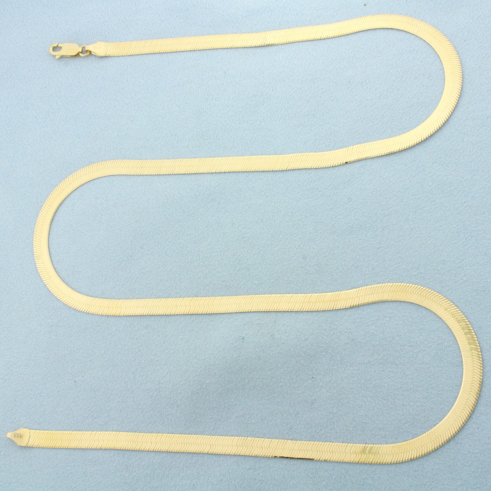 Italian 24 Inch Reversable Herringbone Link Necklace in 14k Yellow Gold: In 14k Yellow Gold. 24 inches long. 5mm wide. High polish on one side and unique oval design on reverse. Italian made. Lobster clasp. 13.6g.