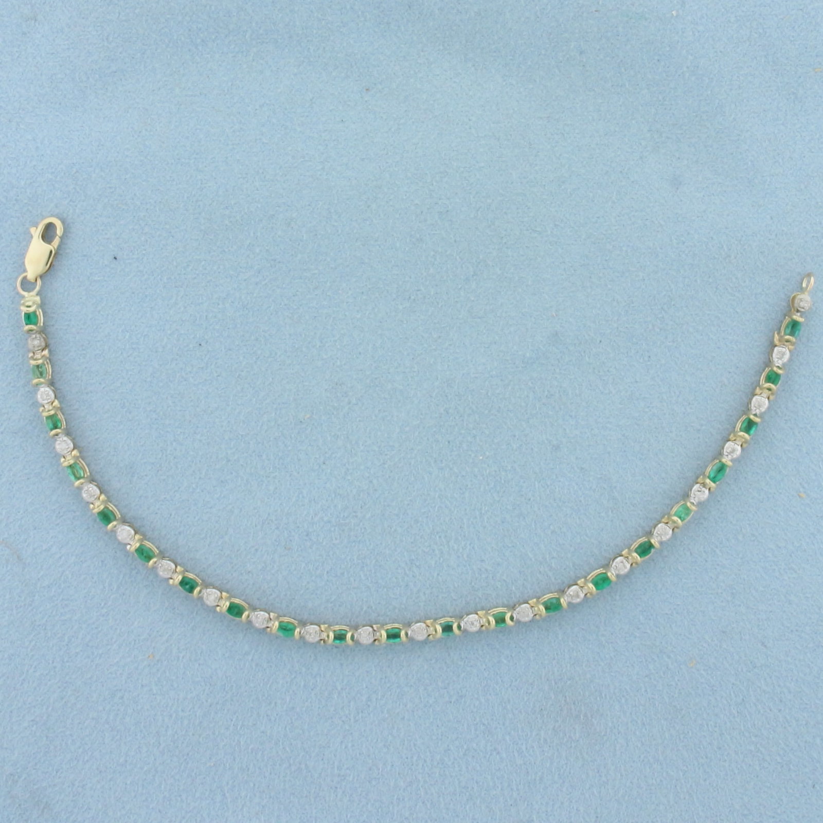 Emerald and Diamond Line Bracelet in 10k Yellow Gold: In 10k Yellow Gold. Contains twenty-two 4mm high quality oval natural Emerald gemstones, approximately 1.5ct TW, with vibrant color. Also contains twenty-two high quality 1/2pt diamonds. 7 inches long