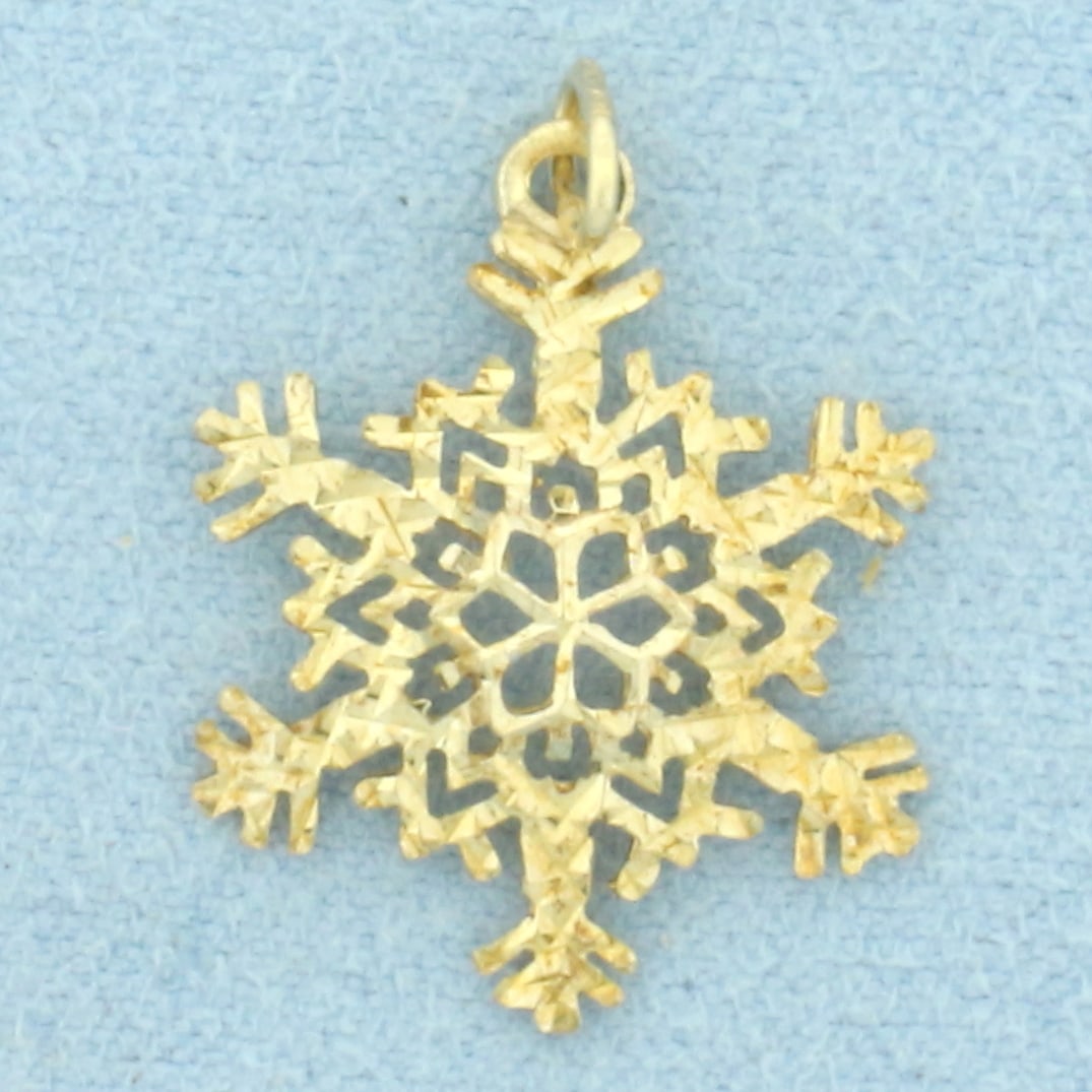 Snowflake Pendant or Charm in 10k Yellow Gold: In 10k Yellow Gold. 7/8 inch long (including jump ring). 5/8 inch wide. .7g.