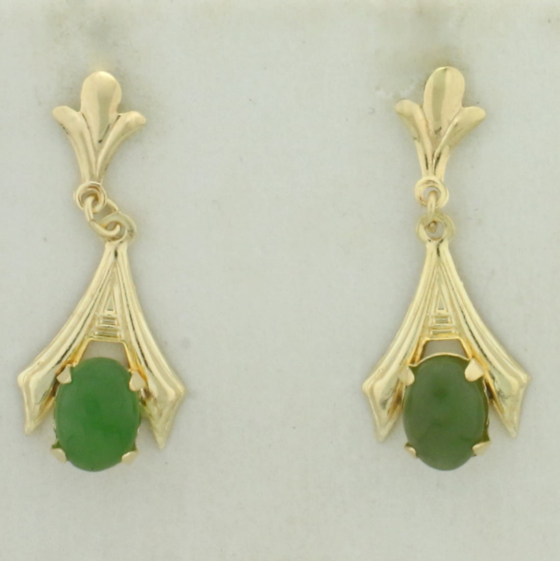 Jade Dangle Earrings in 14k Yellow Gold: In 14k Yellow Gold. Contains two 5x7mm high quality natural Jade gemstones with beautiful intense green color. 1 inch long. 3/8 inch wide. Friction backs. 1.4g.