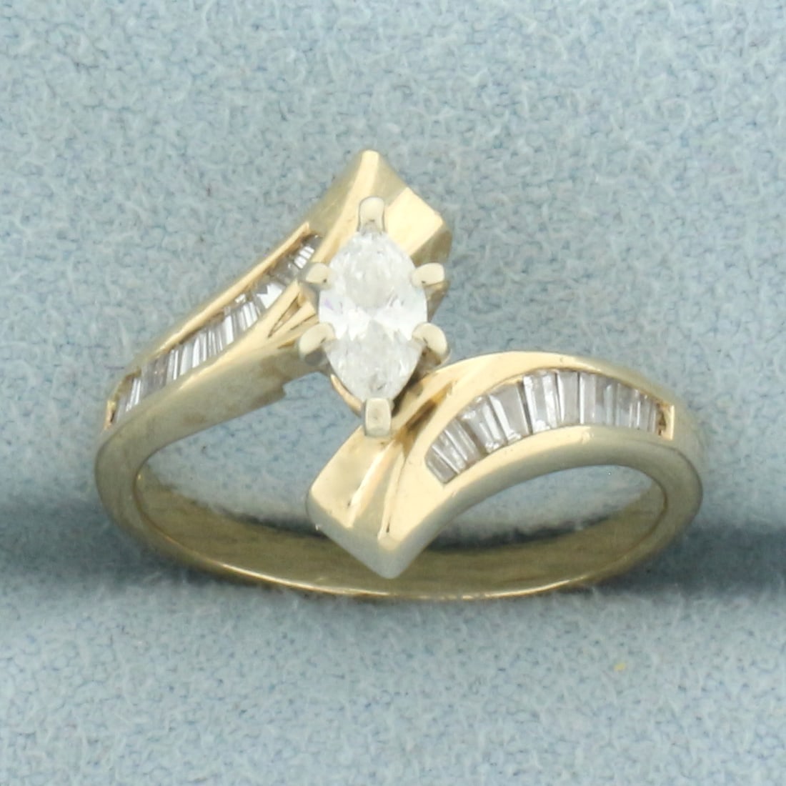 Marquise Diamond Bypass Engagement Ring in 14k Yellow Gold: In 14k yellow gold. Contains 1 high quality marquise cut diamond, 1/4ct, VS clarity/H color. Also contains 24 high quality baguette diamonds, 1/4ct TW, of similar high quality. Size 5. 3.1g.