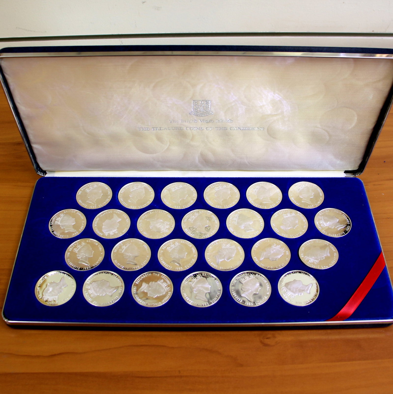 1985 British Virgin Islands Treasure Coins of the Caribbean Collection: Contains twenty-five Sterling Silver 1985 British Virgin Islands Treasure Proof Coins of the Caribbean. Includes original box/coin holder.