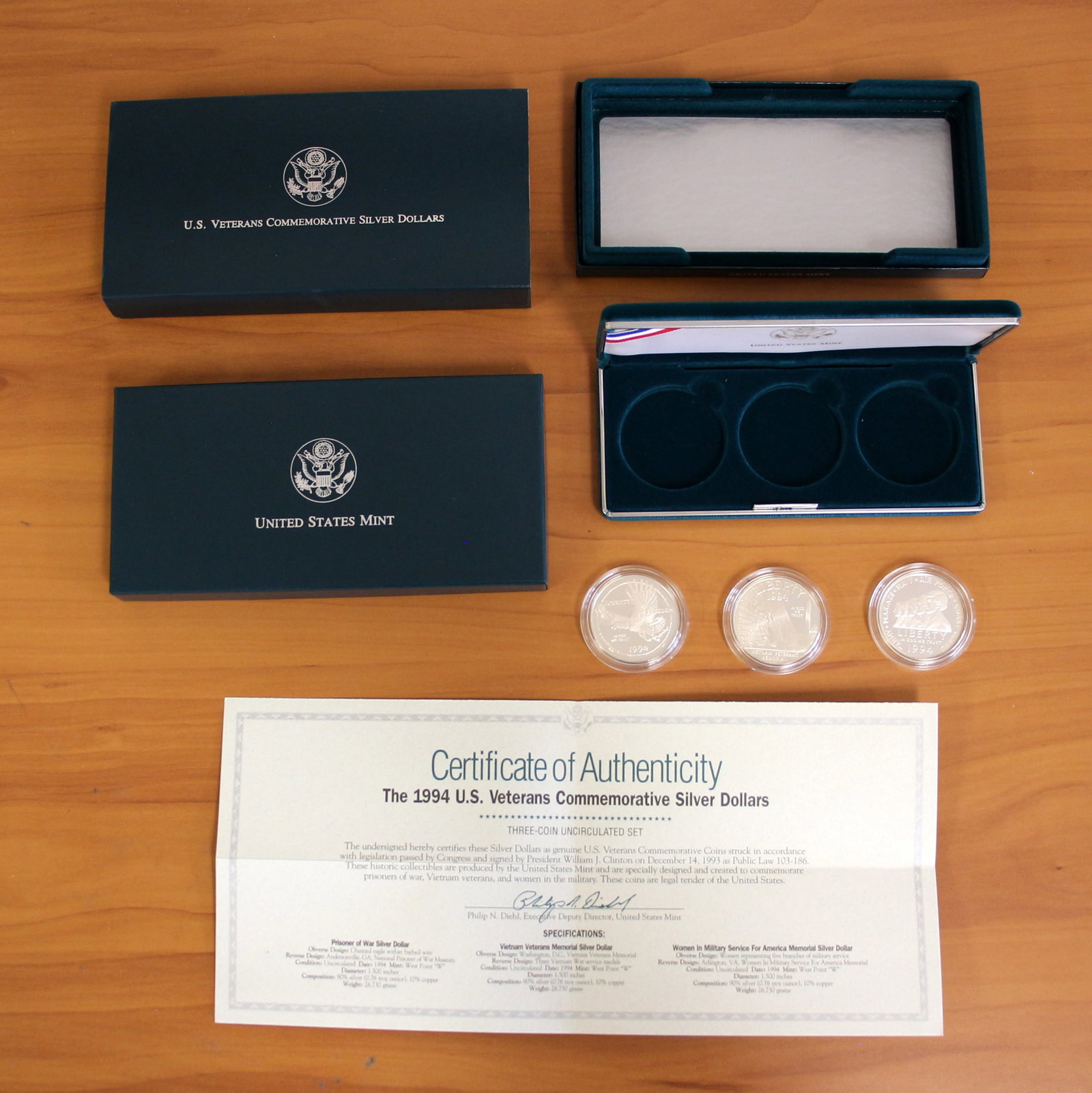 US Mint 1994 Veterans Commemorative Silver Dollar Proof Coin Set OGP: Contains three 90% silver dollars: Prisoner of War, Vietnam Veterans Memorial, Women in Military Service for America Memorial. Includes original casing, packaging, and CoA.