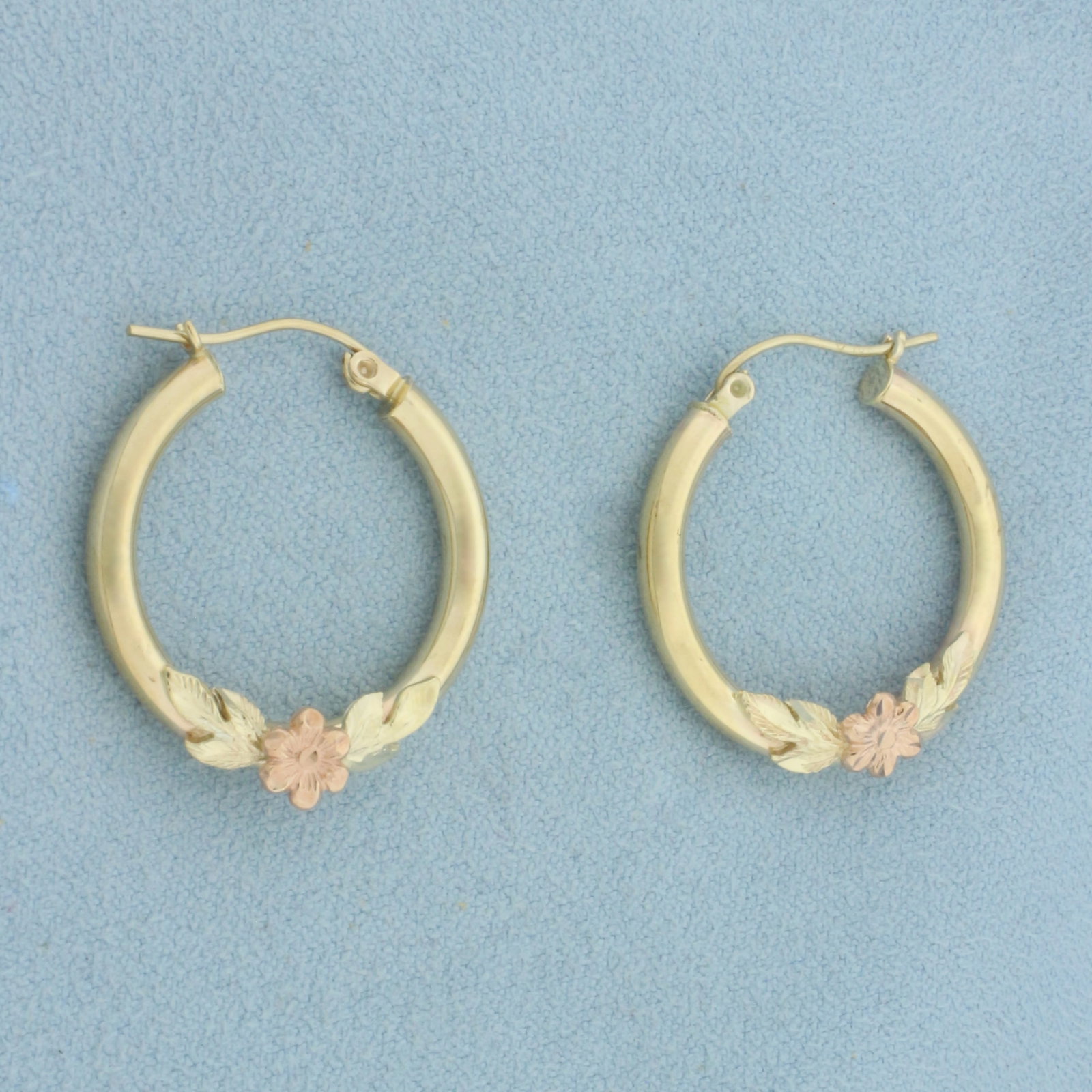 Flower Hoop Earrings in 10k Yellow and Rose Gold: In 10k Yellow and Rose Gold. 1 inch long. 1 inch diameter. 2.7mm wide tubes. Hinged closure. 2.6g.