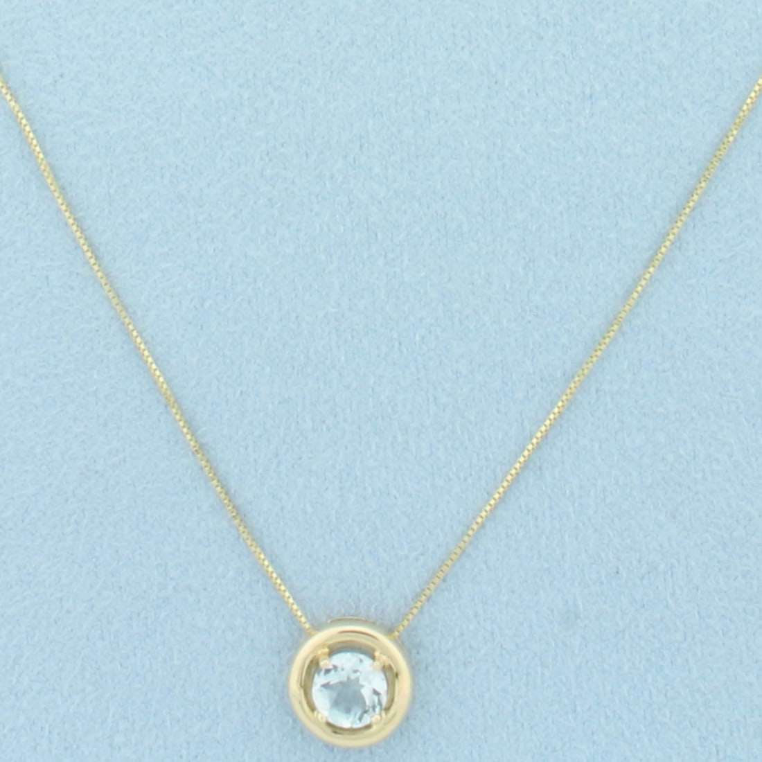 Aquamarine Necklace in 10k Yellow Gold: In 10k Yellow Gold. Contains one 6mm high quality natural Aquamarine gemstone, approximately 3/4cts, with vibrant color and excellent clarity. Pendant is 10.3mm wide. Box link chain is 19 inches long 