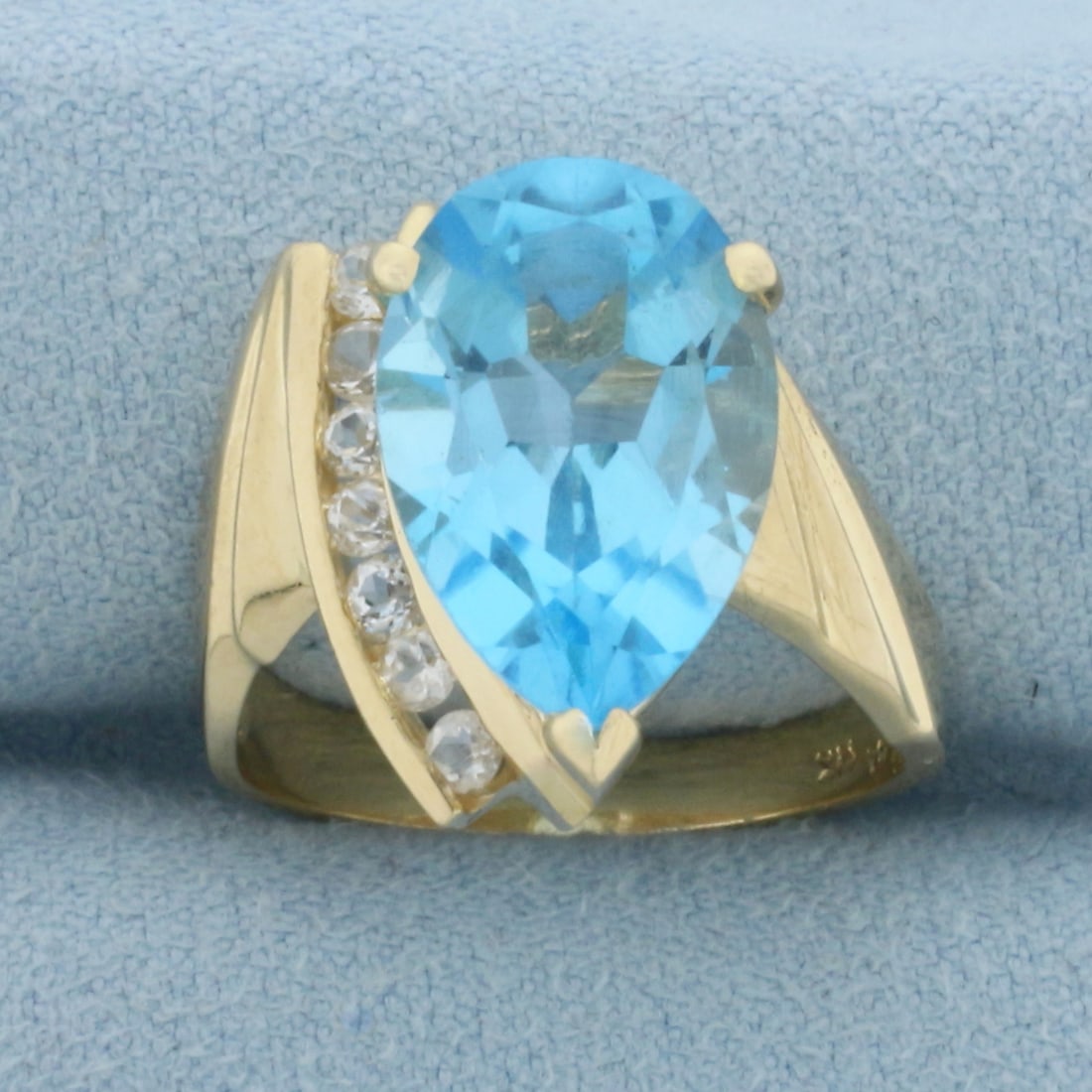 Swiss Blue Topaz and White Sapphire Ring in 14k Yellow Gold: In 14k Yellow Gold. Contains one 15x10mm high quality natural Swiss Blue Topaz gemstone, approximately 6cts, with electric blue color and excellent clarity. Also contains seven high quality .03ct