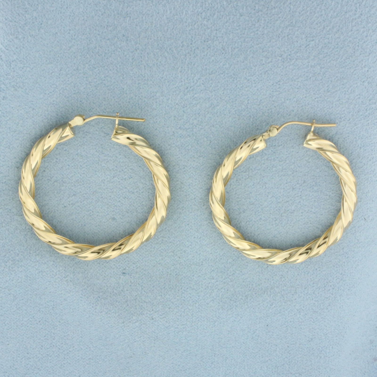 Twisting Hoop Earrings in 14k Yellow Gold: in 14k Yellow Gold. 1 1/4 inch long by 1/4 inch wide. 2.7g.