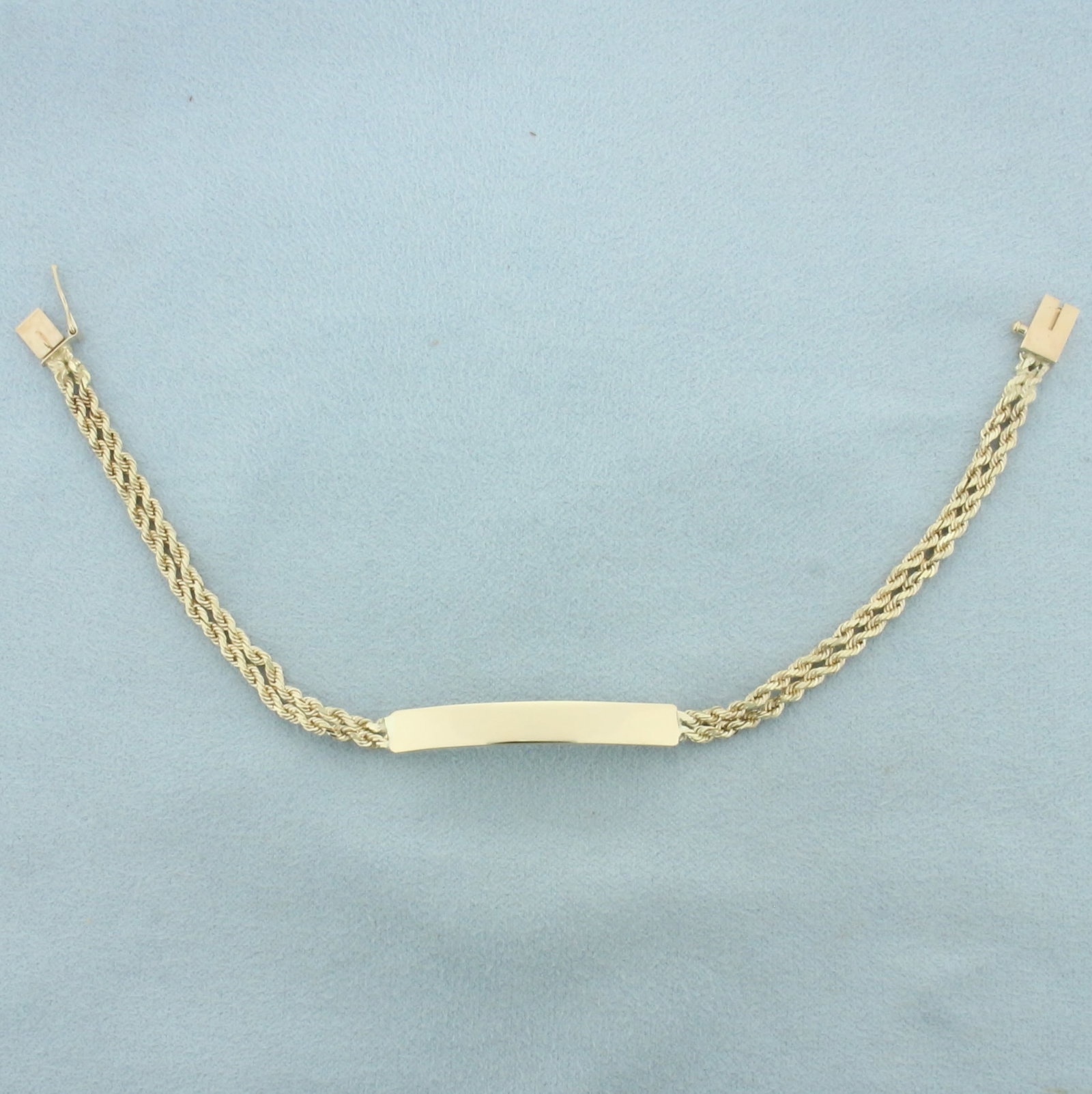 ID Nameplate Rope Bracelet in 14k Yellow Gold: In 14k yellow gold. 7 1/4 inches long and 5.25mm wide. Plaque is 1.5 inches long. Slide clasp, safety latch. 6.8g.