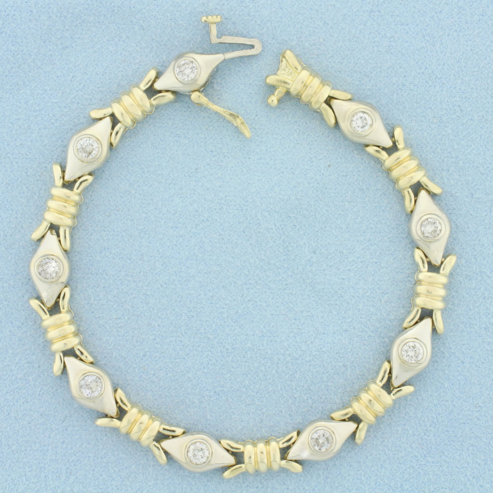 Diamond Evil Eye Design Two Tone Bracelet in 14k Yellow and White Gold: In 14k yellow and white gold. Contains nine high quality diamonds, 1 1/2ct TW, SI2 clarity/H color. 6 3/4 inches long, 6mm wide. Slide clasp with safety latch. 14.3g.