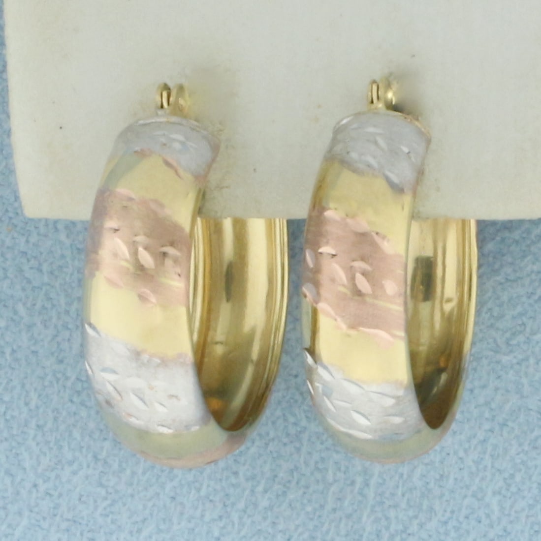Tri-Color Hoop Earrings in 10k Yellow, White, and Rose Gold: In 10k Yellow, White, and Rose Gold. 3/4 inch diameter. 6mm wide. Hinged closure. 1.7g.