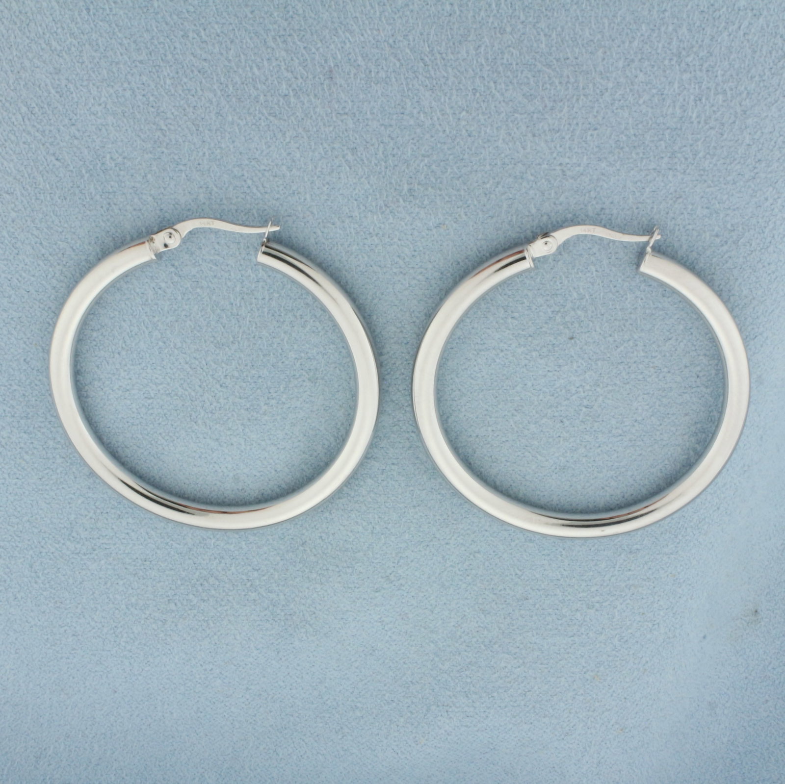 Italian Hoop Earrings in 14k White Gold: In 14k White Gold. 1 3/8 inch diameter. 3mm wide. Italian made. Hinged closure. 2.8g.