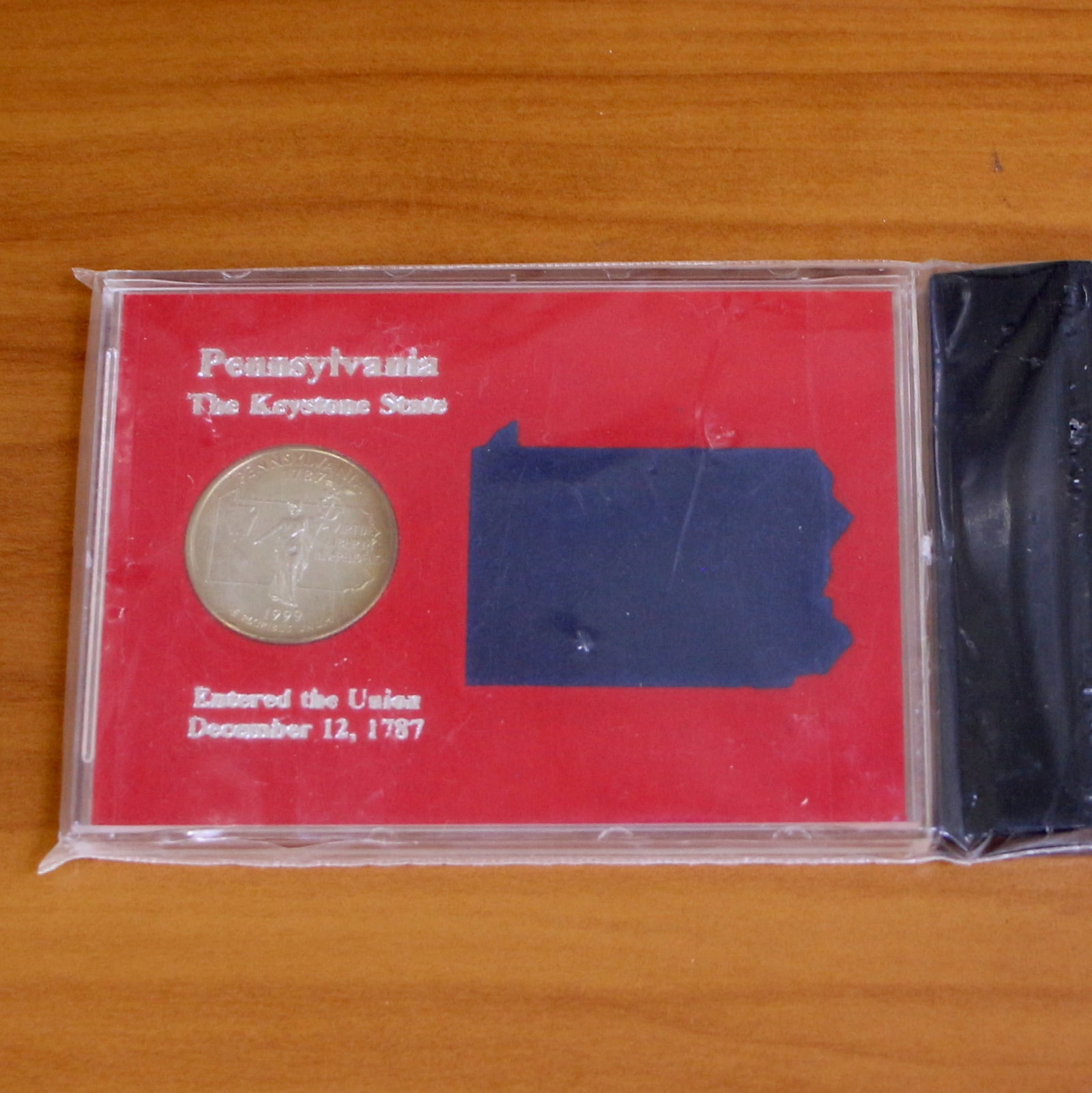 1999 Pennsylvania State Quarter In Case With Stand: Contains one 1999 Pennsylvania State Quarter. Set in plastic casing and contains display holder.