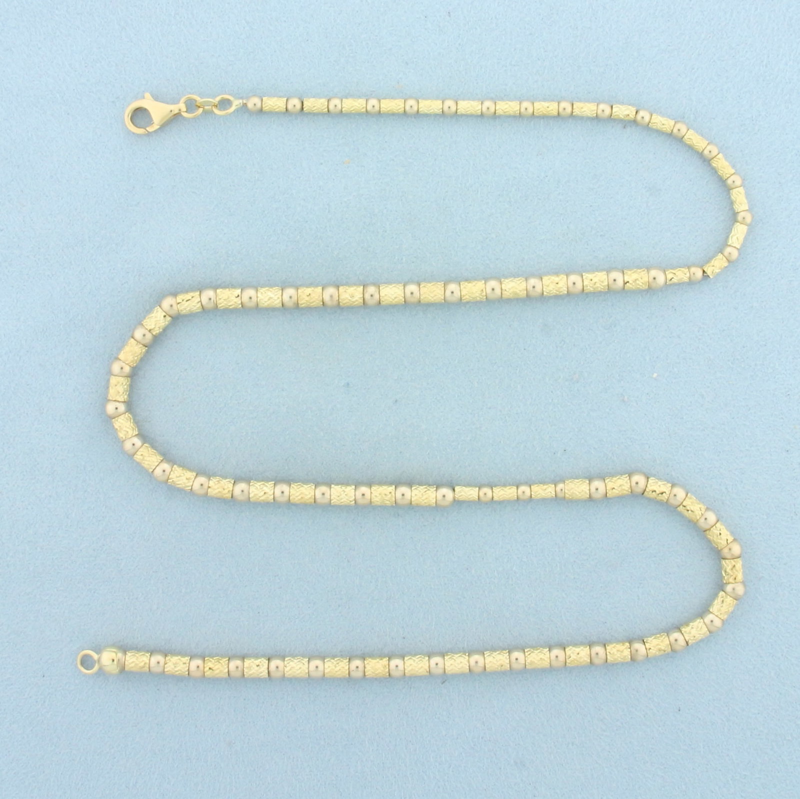 19 Inch Diamond Cut Gold Bead Necklace in 14k Yellow Gold: In 14k Yellow Gold. 19 inches long. 4mm thick. Lobster clasp. 20.3g.