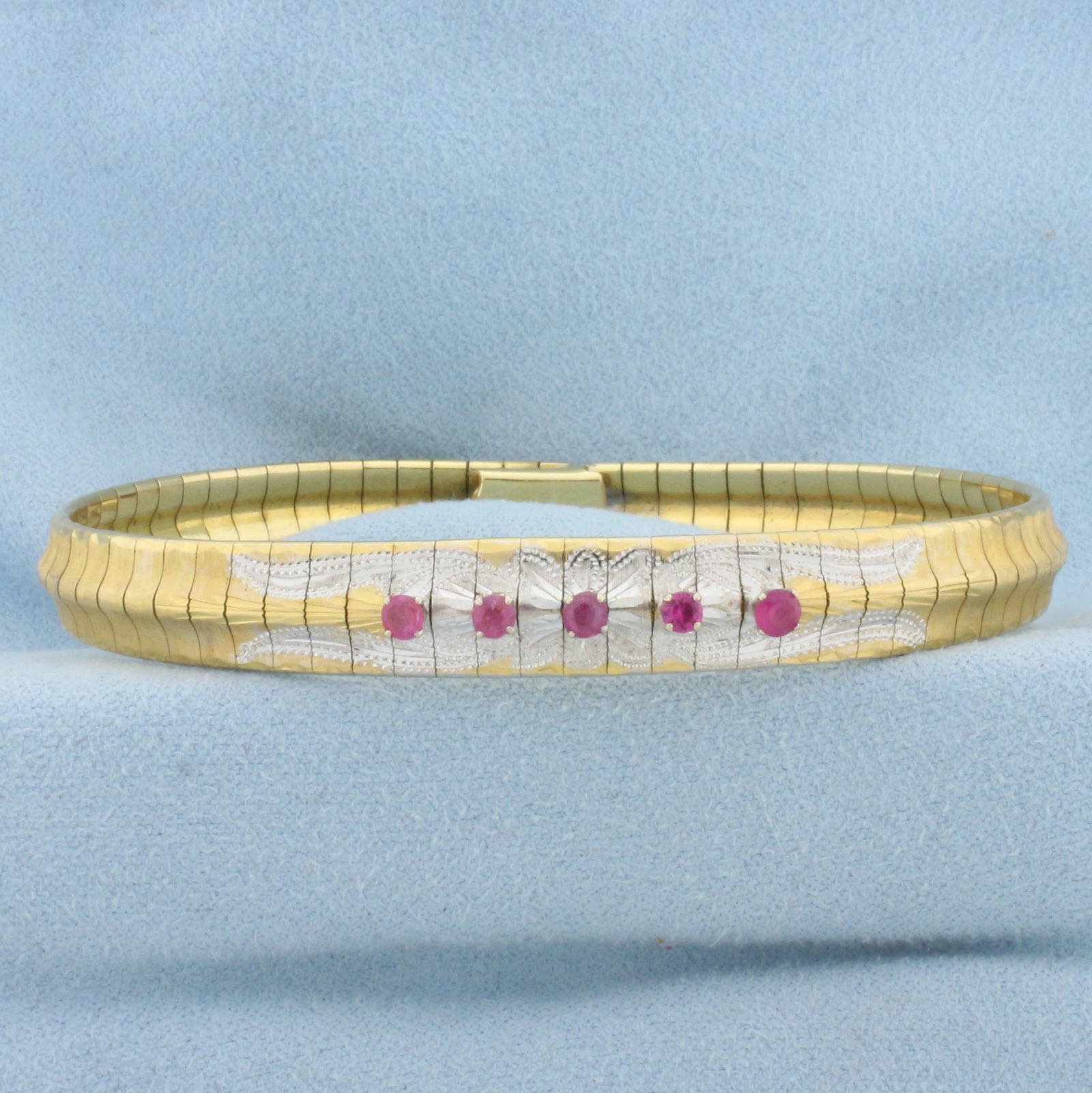 Pink Sapphire Omega Bracelet in 18K Yellow and White Gold: In 18K Yellow and White Gold. Contains five high quality 3mm round Pink Sapphire gemstones, approximately 1/2ct TW, with bright pink color and excellent clarity. 7 1/2 inches long. 8.3mm wide. Safety 
