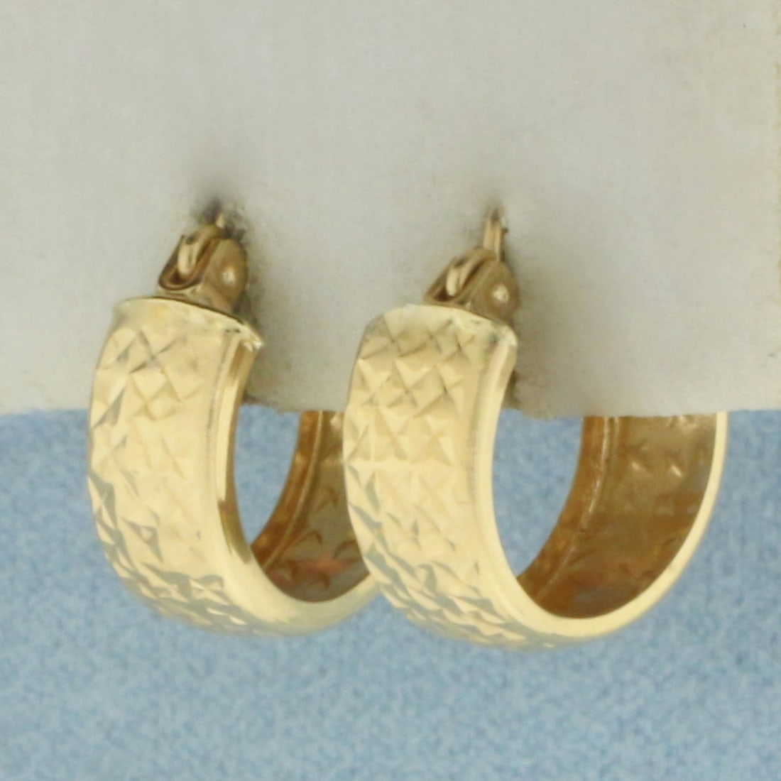 Diamond Cut Huggie Hoop Earrings in 14k Yellow Gold: In 14k Yellow Gold. 1/2 inch long. 5mm wide. Hinged closure. 1.3g.