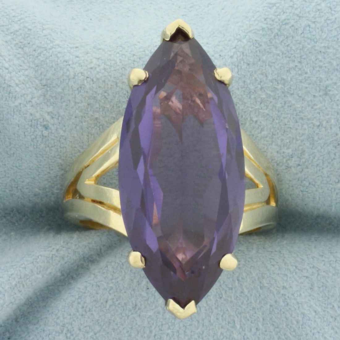 Large Lab Alexandrite Solitaire Statement Ring in 14k Yellow Gold: In 14k Yellow Gold. Contains one 29x12.5mm high quality marquise cut Lab Alexandrite gemstone, approximately 13cts, with intense color change from purple to red under different lighting conditions and