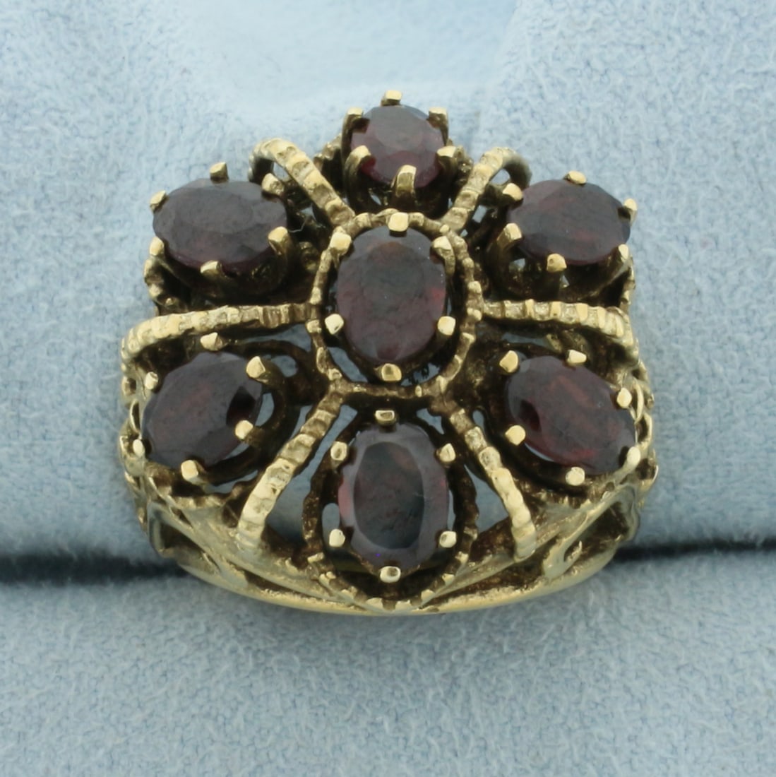 Victorian Revival Garnet Ring in 14k Yellow Gold: In 14k yellow gold. Contains 7 high quality natural garnet gemstones, approx. 4ct TW, with beautiful color and excellent clarity. Intricate scrollwork on shoulders of ring. Measures 22.4mm wide at wid