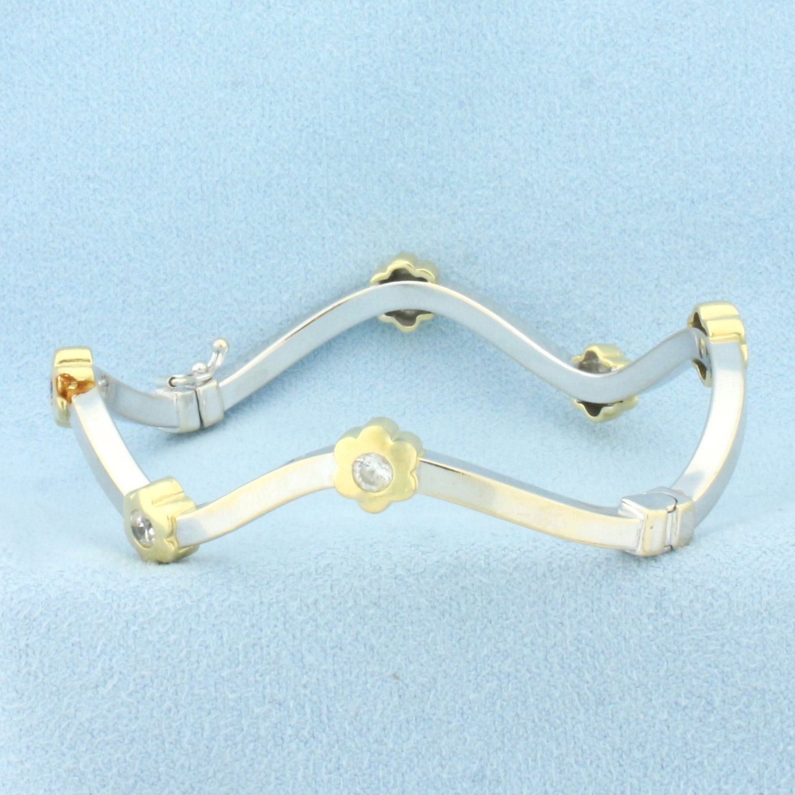Flower Station Bangle Bracelet in 18k White and Yellow Gold: In 18k white and yellow gold. Italian made. Contains six high quality .15ct CZ gemstones with excellent clarity and cut for added brilliance. Interior dimensions 2 1/4 inches by 2 inches. Unique wave 