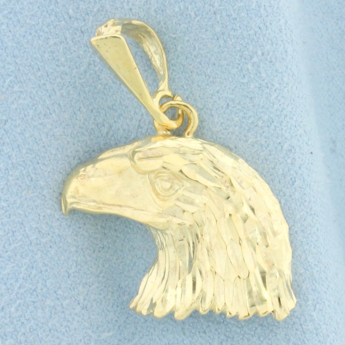 Diamond Cut American Bald Eagle Pendant in 14k Yellow Gold: In 14k Yellow Gold. 1 1/4 inch long. 7/8 inch wide. 5.9g.